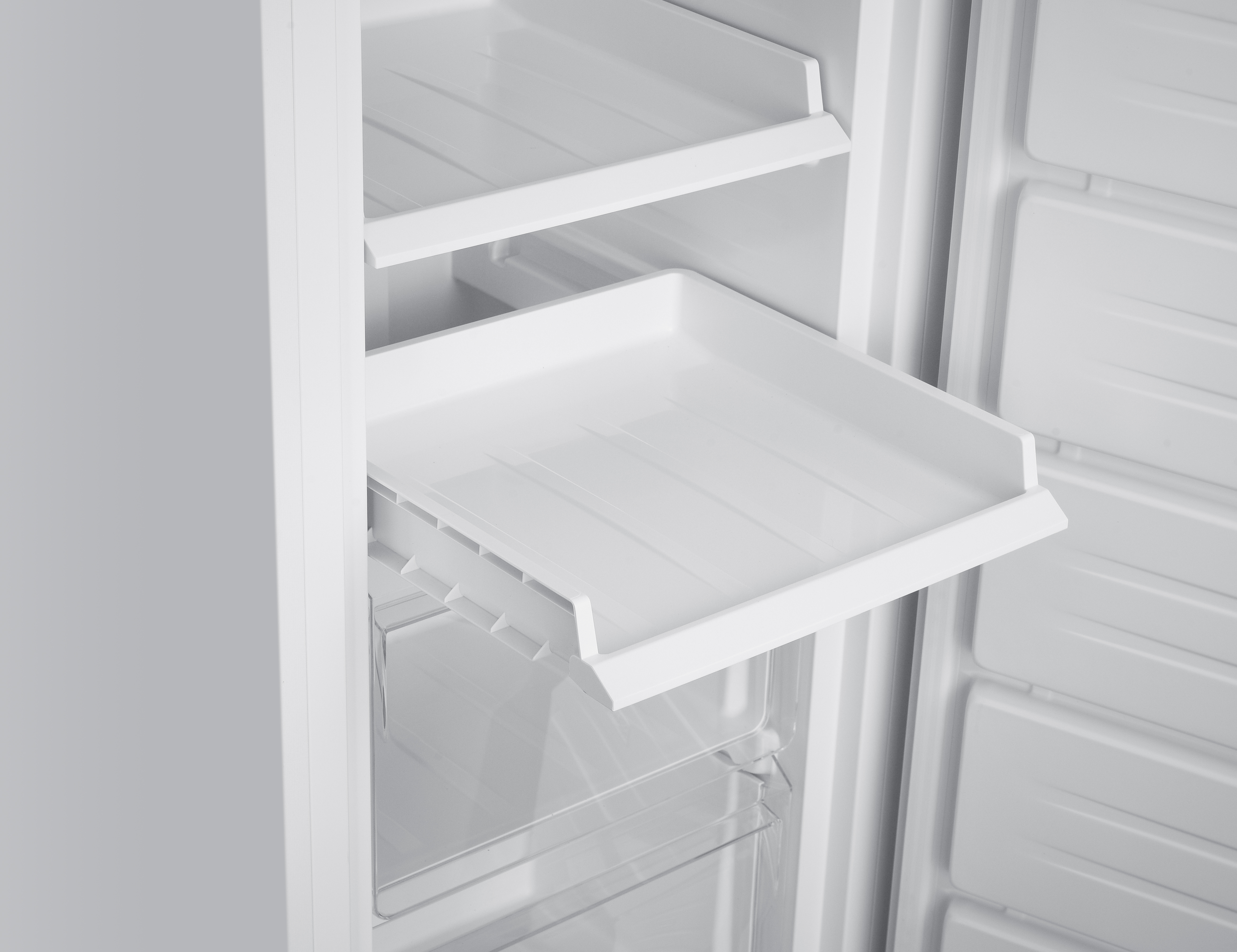 Offener weißer Kühlschrank mit Regalen und einem ausziehbaren Fach. Innenraum ist ganz weiß. Klare Plastikschubladen.