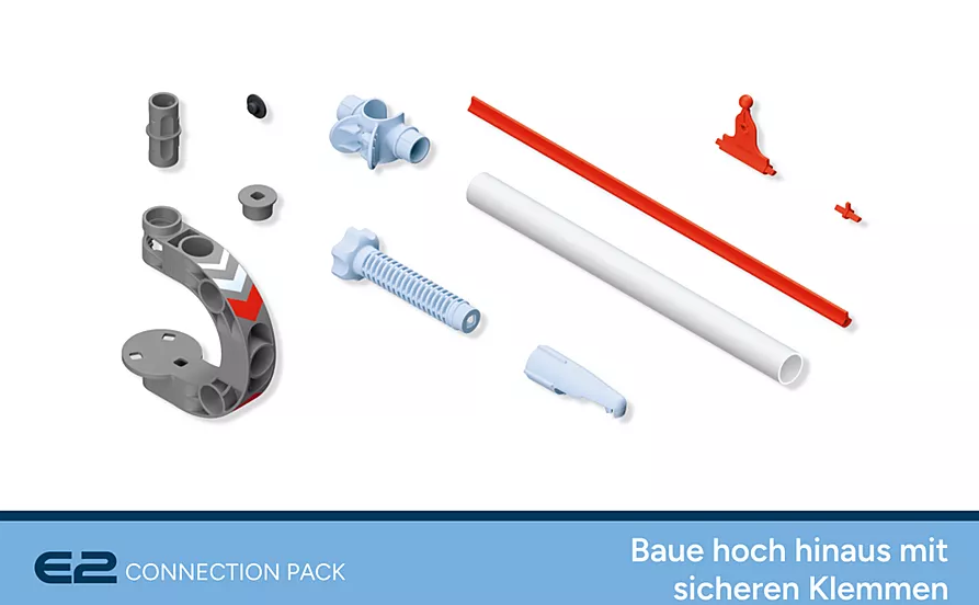 Verschiedene Konstruktionsbauteile auf Weiß. Graue, weiße, rote und blaue Komponenten sind verstreut, darunter Rohre und Verbinder.