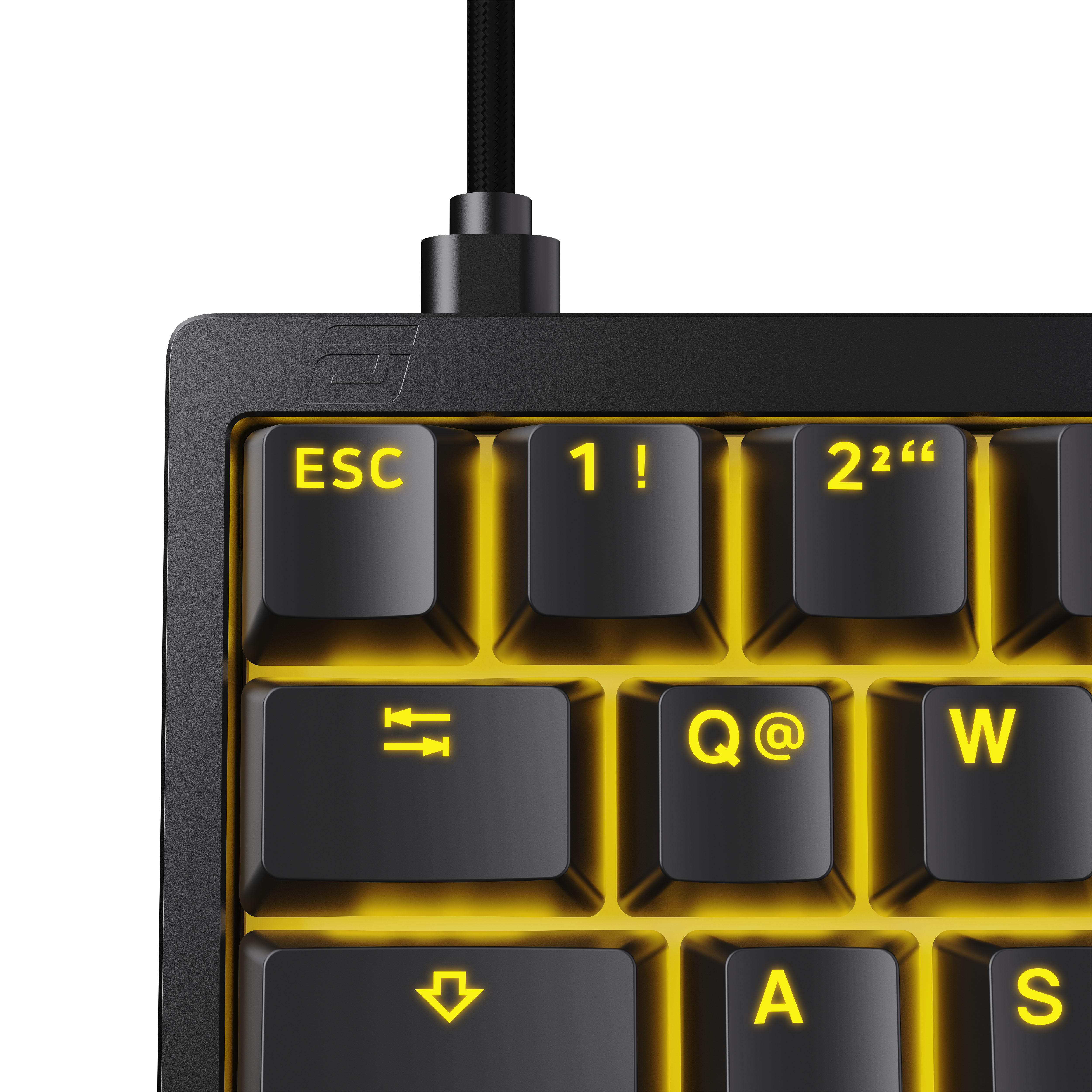 Nahaufnahme einer schwarzen Tastatur mit gelb hinterleuchteten Tasten. Zeigt ESC, 1!, Q@, W, A, S Tasten. Schwarzes Kabel oben.