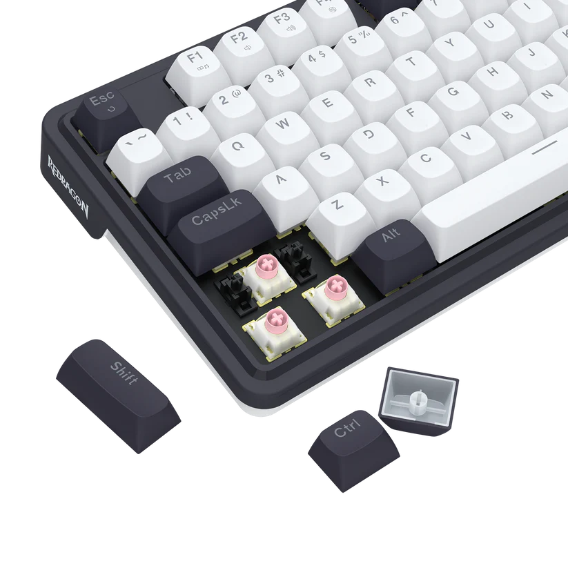 Klawiatura mechaniczna z białymi i ciemnoszarymi klawiszami. Kilka klawiszy usunięto, ukazując różowe przełączniki. Dodatkowe klawisze, jak Shift i Ctrl, są widoczne.