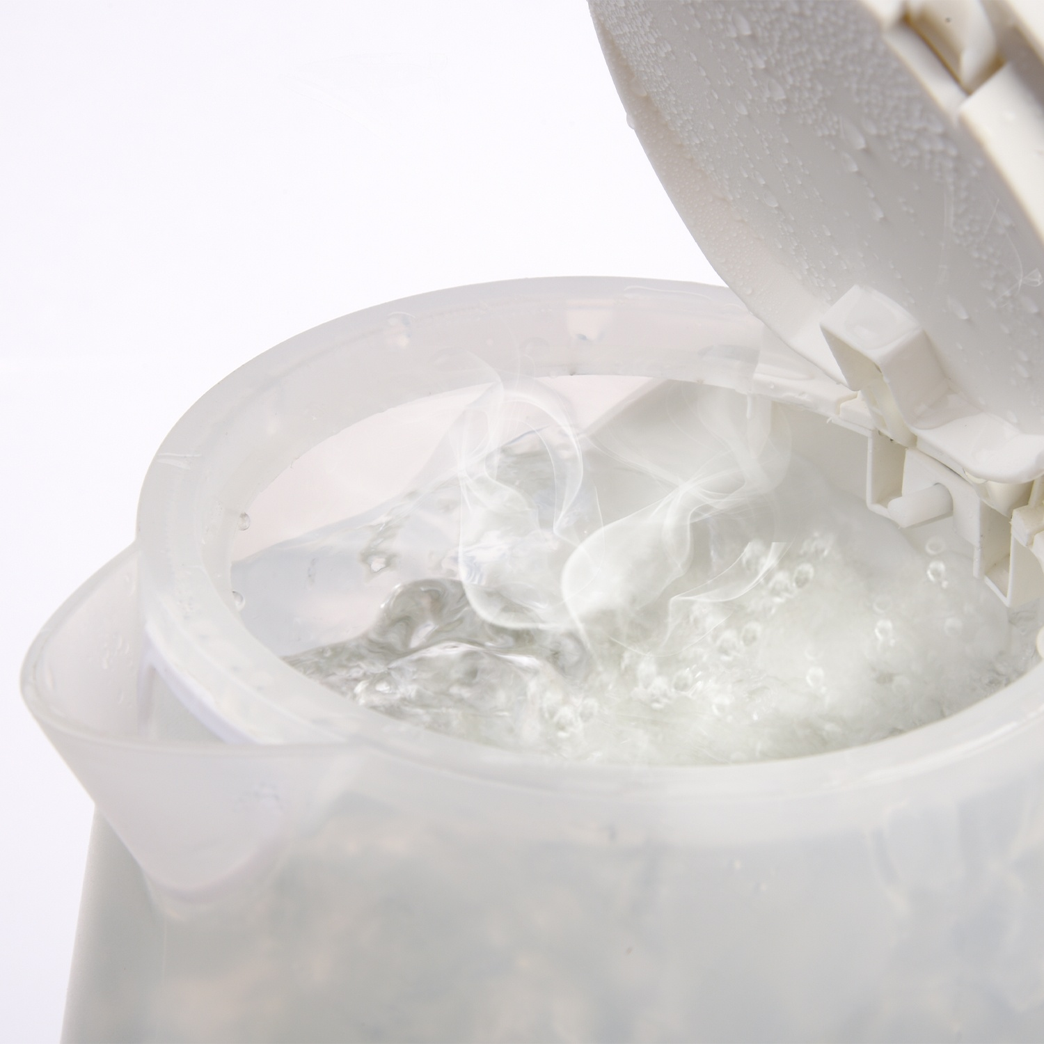 Un bollitore elettrico trasparente con acqua bollente. Il vapore sale, il coperchio è aperto, con condensa.