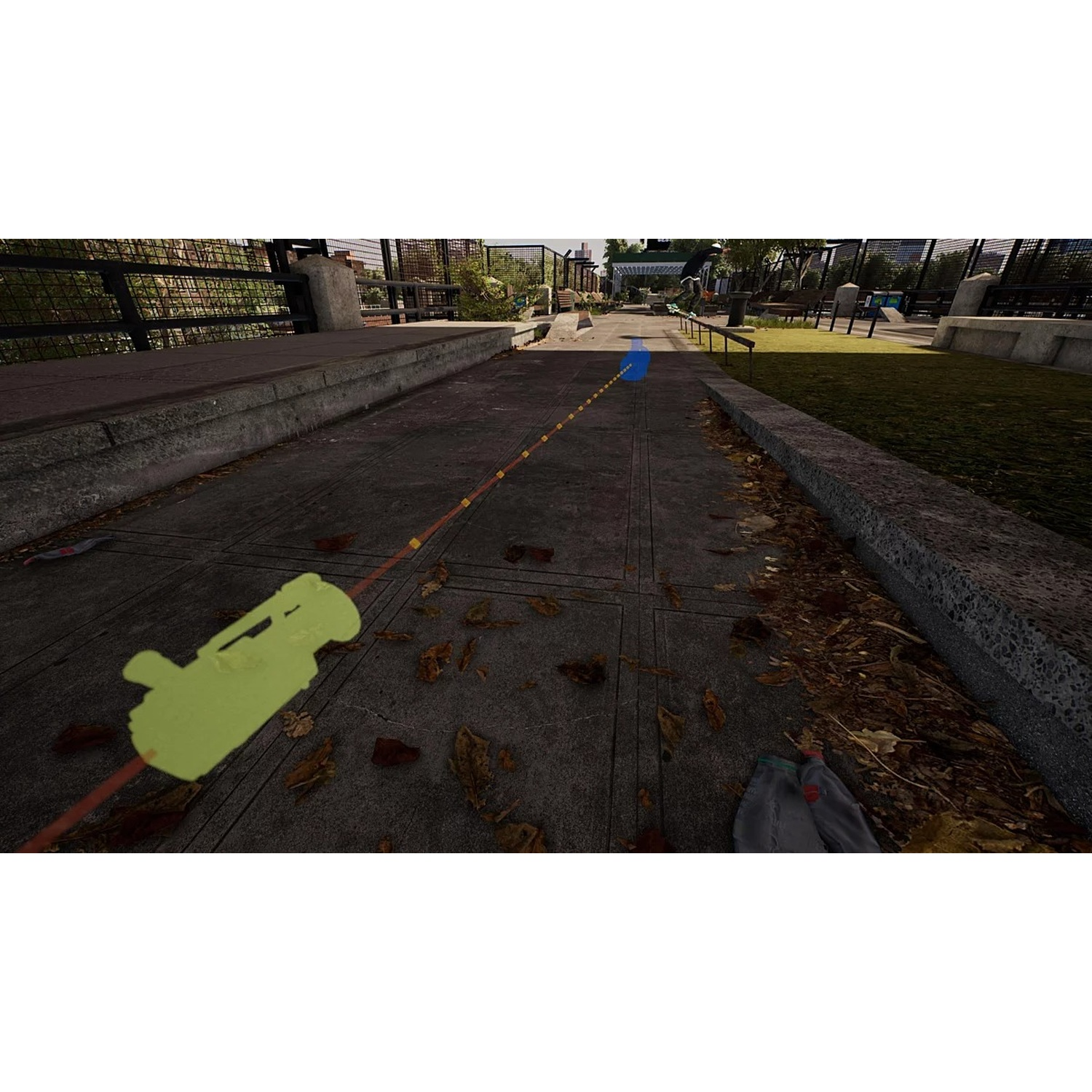 Een stoep in een park met een geel object en een blauwe markering. Het pad heeft bladeren. Banken en bomen op de achtergrond.
