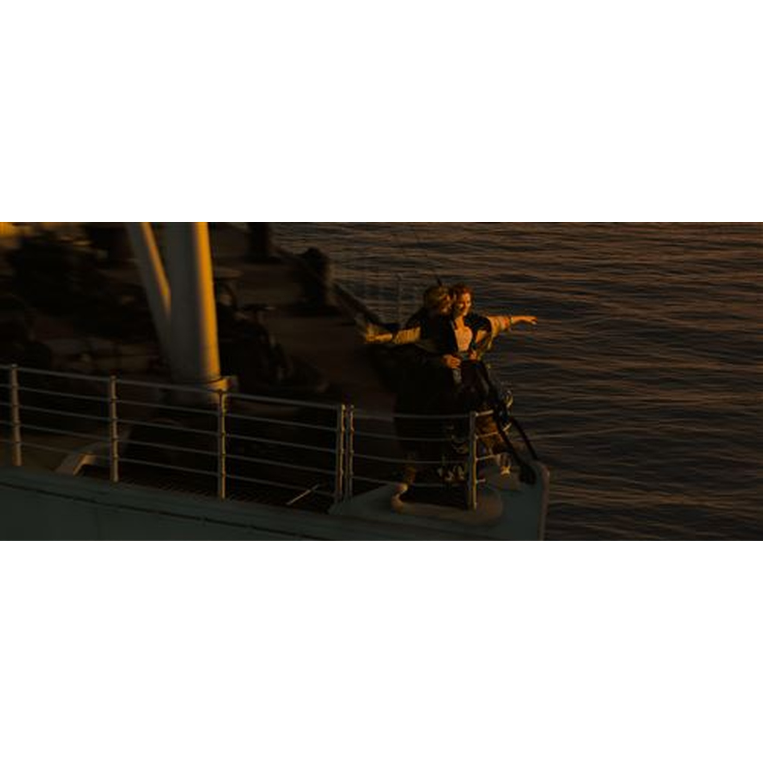 Een stel staat op het dek van een schip, met uitgestrekte armen, tegen een zonsondergang boven de zee. De structuur van het schip is zichtbaar.