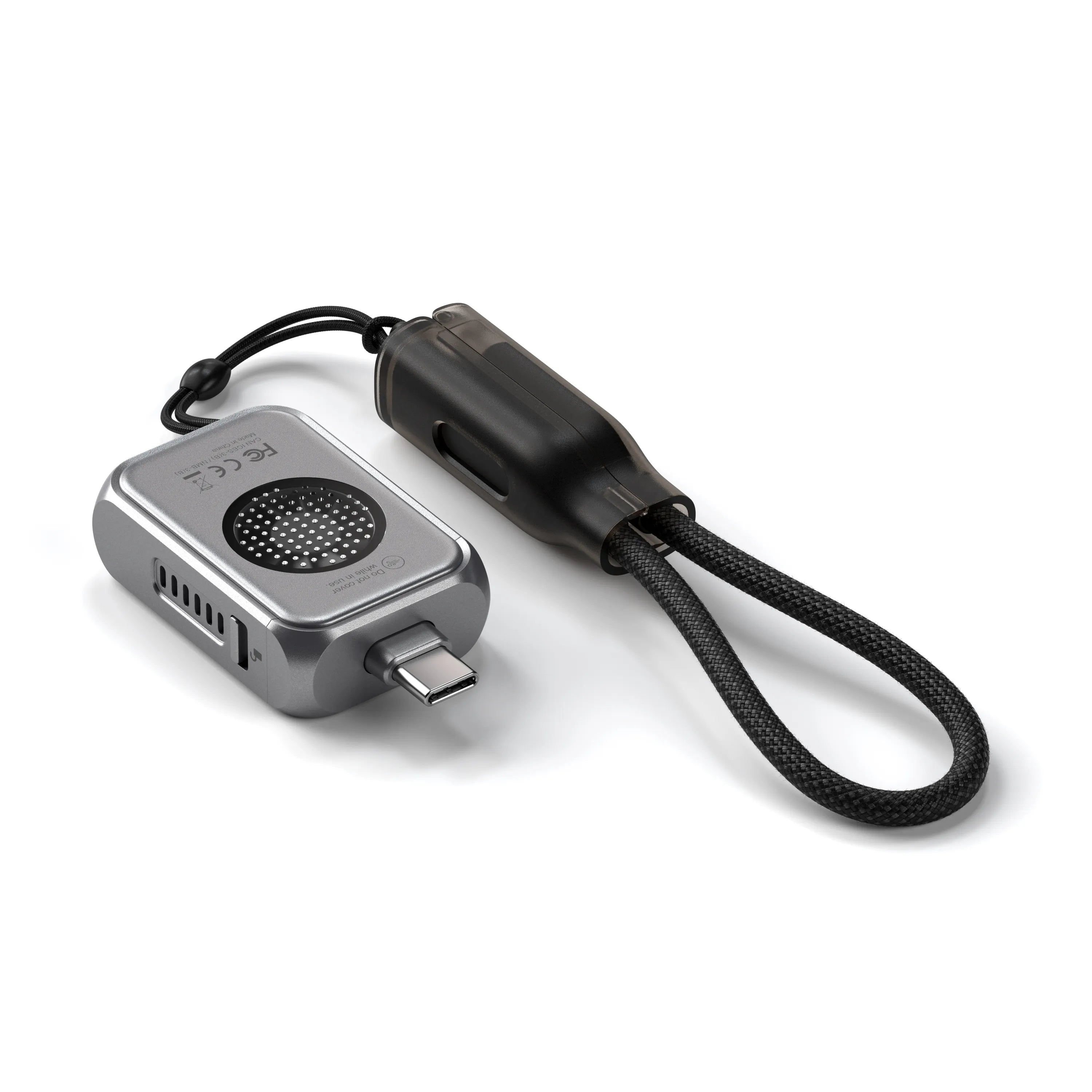 Ein silbernes Gerät mit schwarzem Riemen. Das Gerät hat einen USB-C-Anschluss und einen Lautsprecher. Der Riemen ist geflochten.