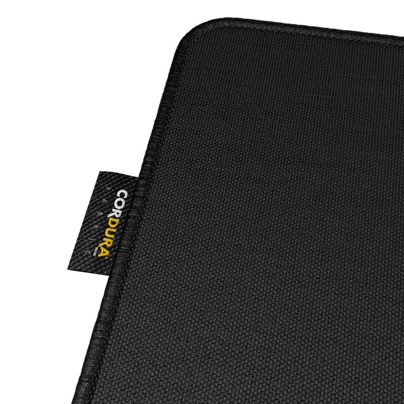 Nahaufnahme eines schwarzen Cordura-Stoffs. Ein Etikett mit 'CORDURA FABRIC BRAND' ist links. Der Stoff hat eine strukturierte Oberfläche.