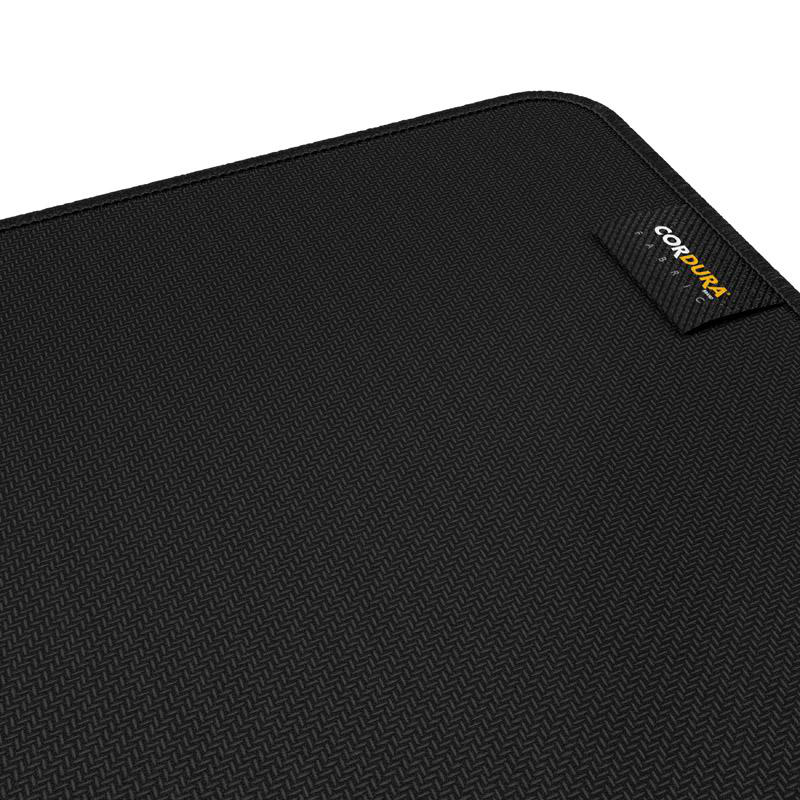 Nahaufnahme eines schwarzen Mauspads mit strukturierter Oberfläche. Das Cordura-Stofflogo ist sichtbar.