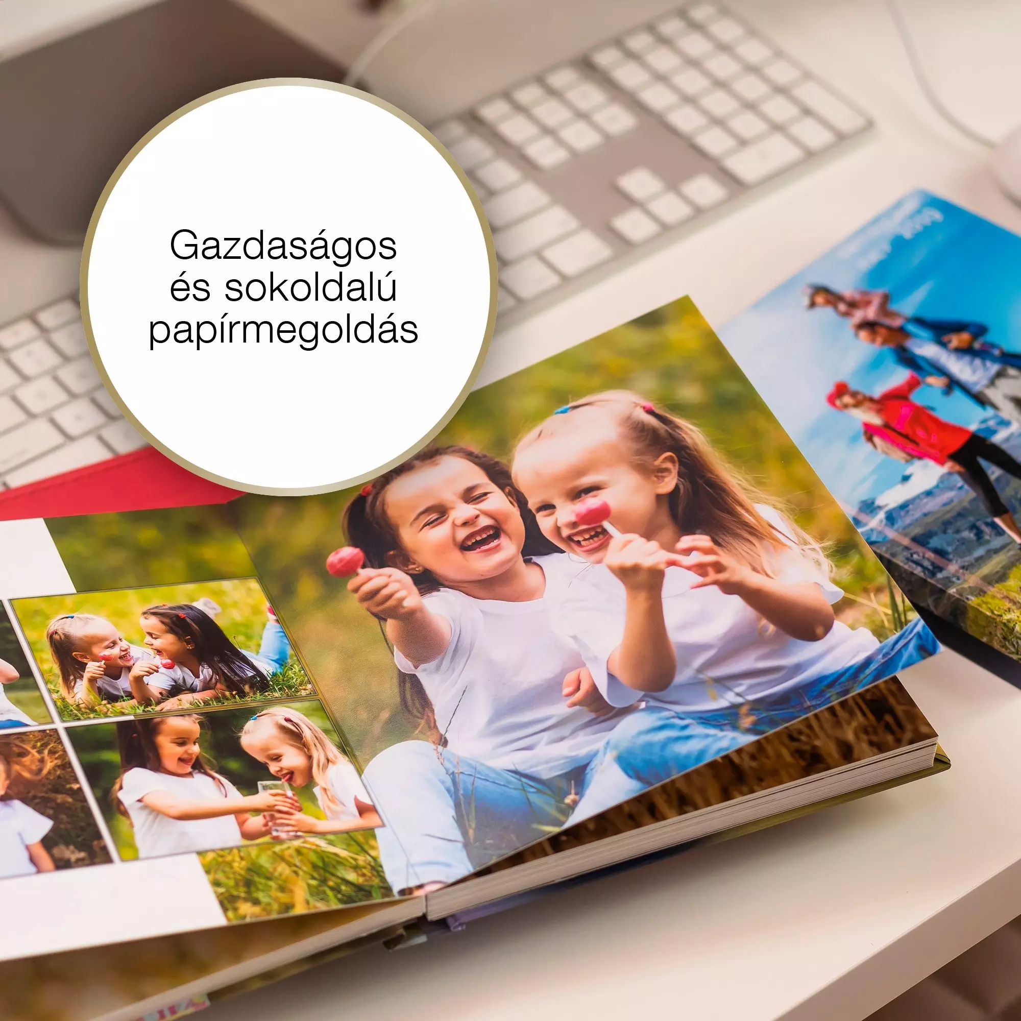 Nyitott fotóalbum, mosolygó lányokkal, nyalókával. Billentyűzet és fotók a háttérben. Fehér felület.