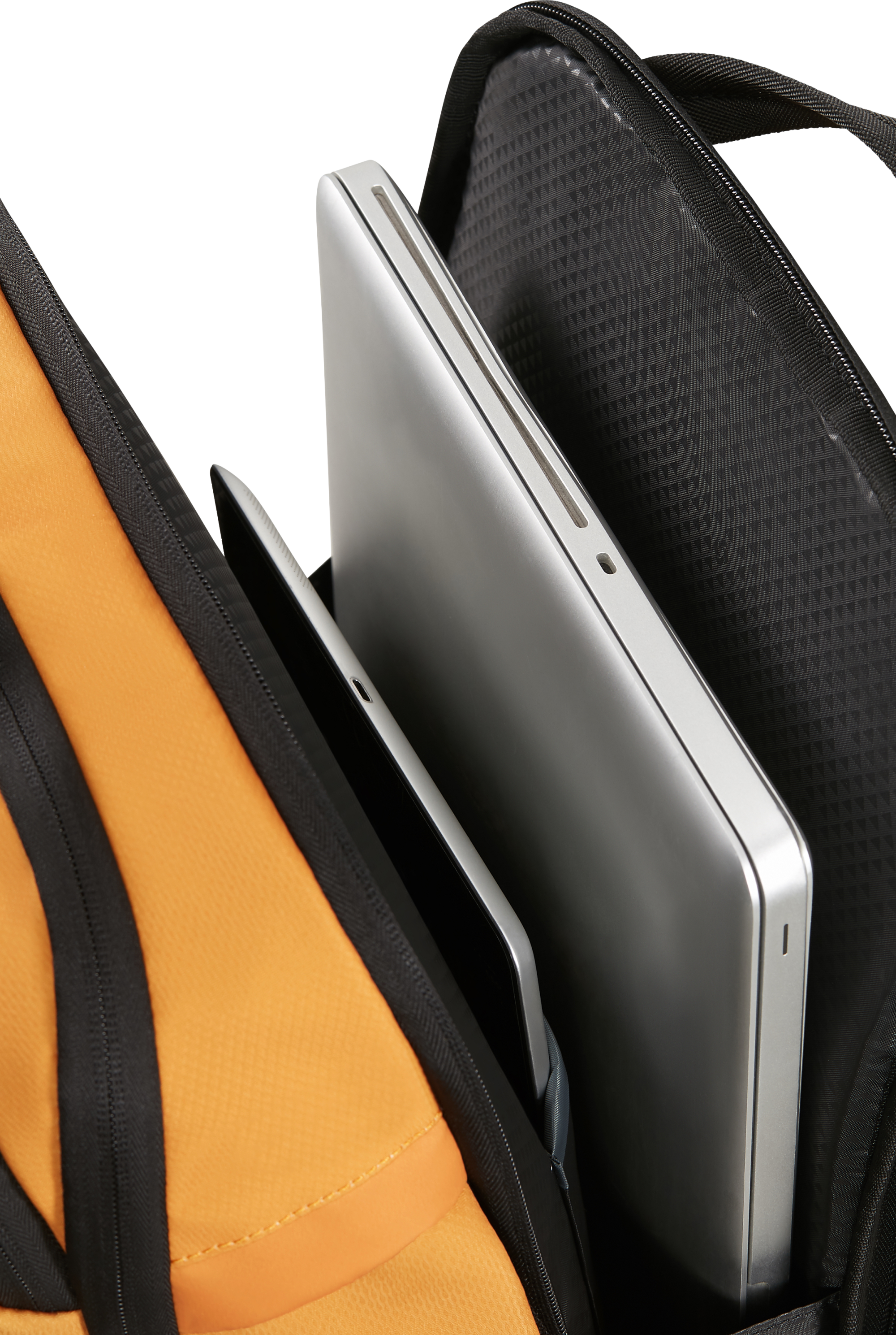 Nyitott fekete hátizsák ezüst laptop-pal és fekete tablettel belül, fekete háttér előtt. Narancssárga belső látható.