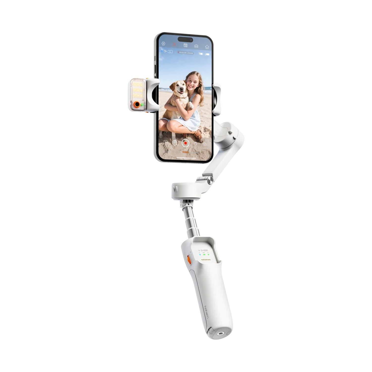 Uno stabilizzatore per telefono bianco tiene un telefono che mostra una ragazza con un cane sulla spiaggia. Lo stabilizzatore è esteso.
