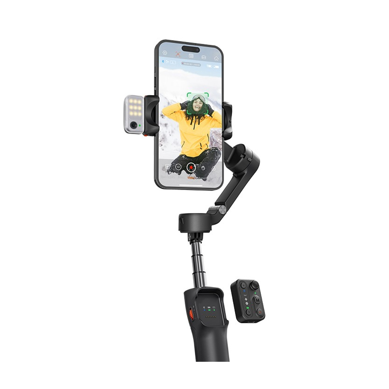 Un telefono su un gimbal, che registra una persona. Ha una luce e un telecomando. La persona indossa una giacca gialla ed è sulla neve.