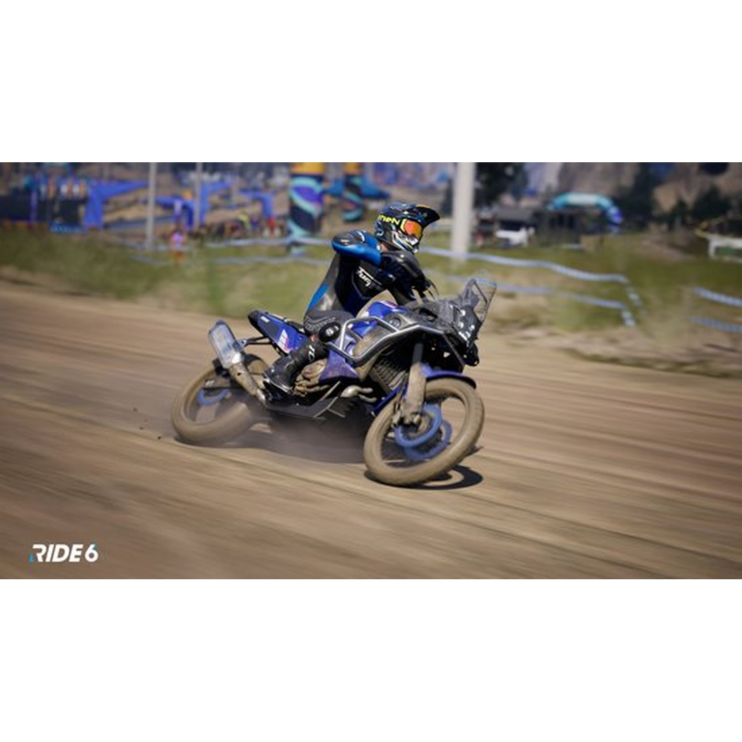 Un motocycliste en équipement bleu et noir roule sur une moto bleue et noire sur une piste de terre. La scène est en extérieur.