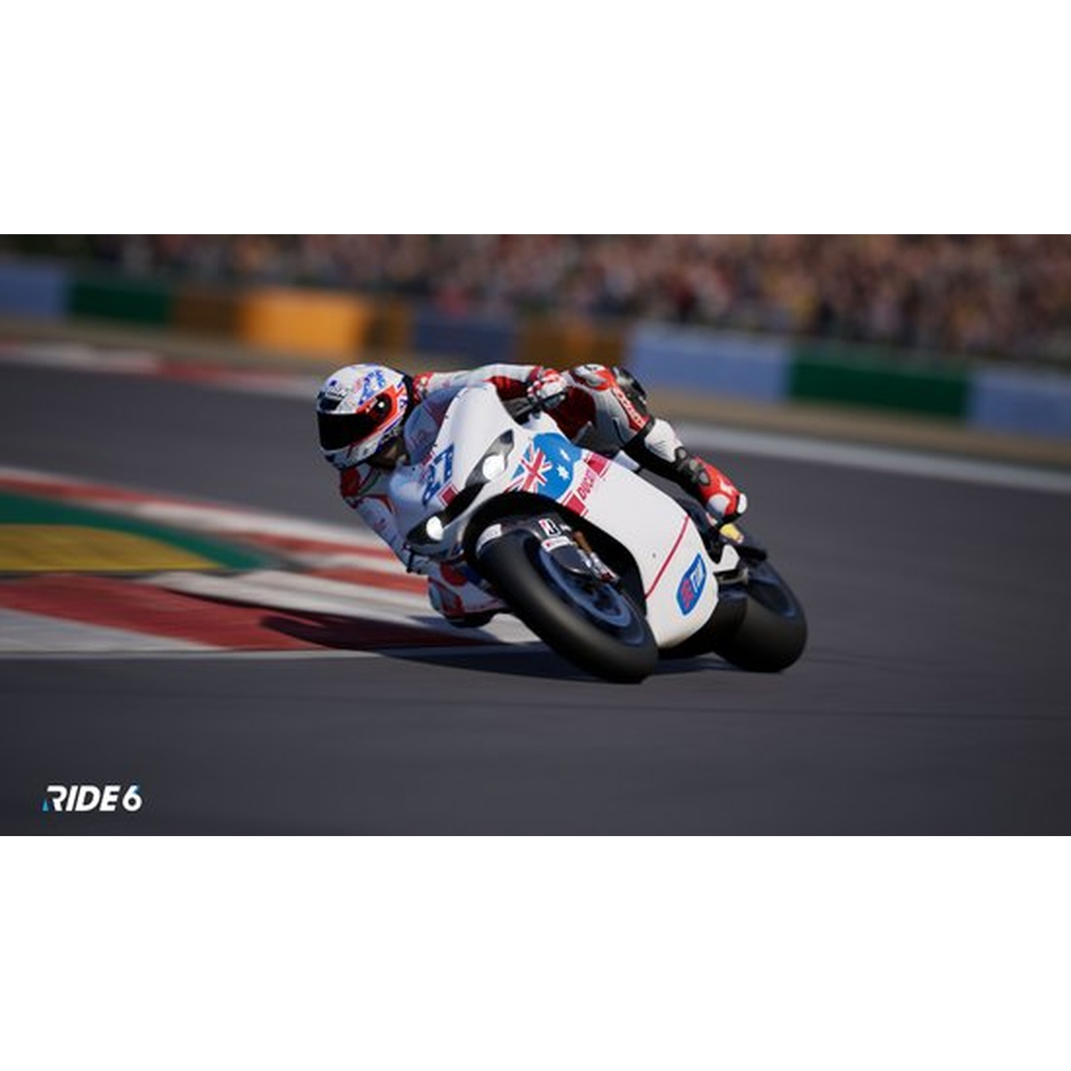 Un motocycliste se penche dans un virage sur une piste. La moto est blanche avec des accents bleus. Le pilote porte un casque et une combinaison blancs.