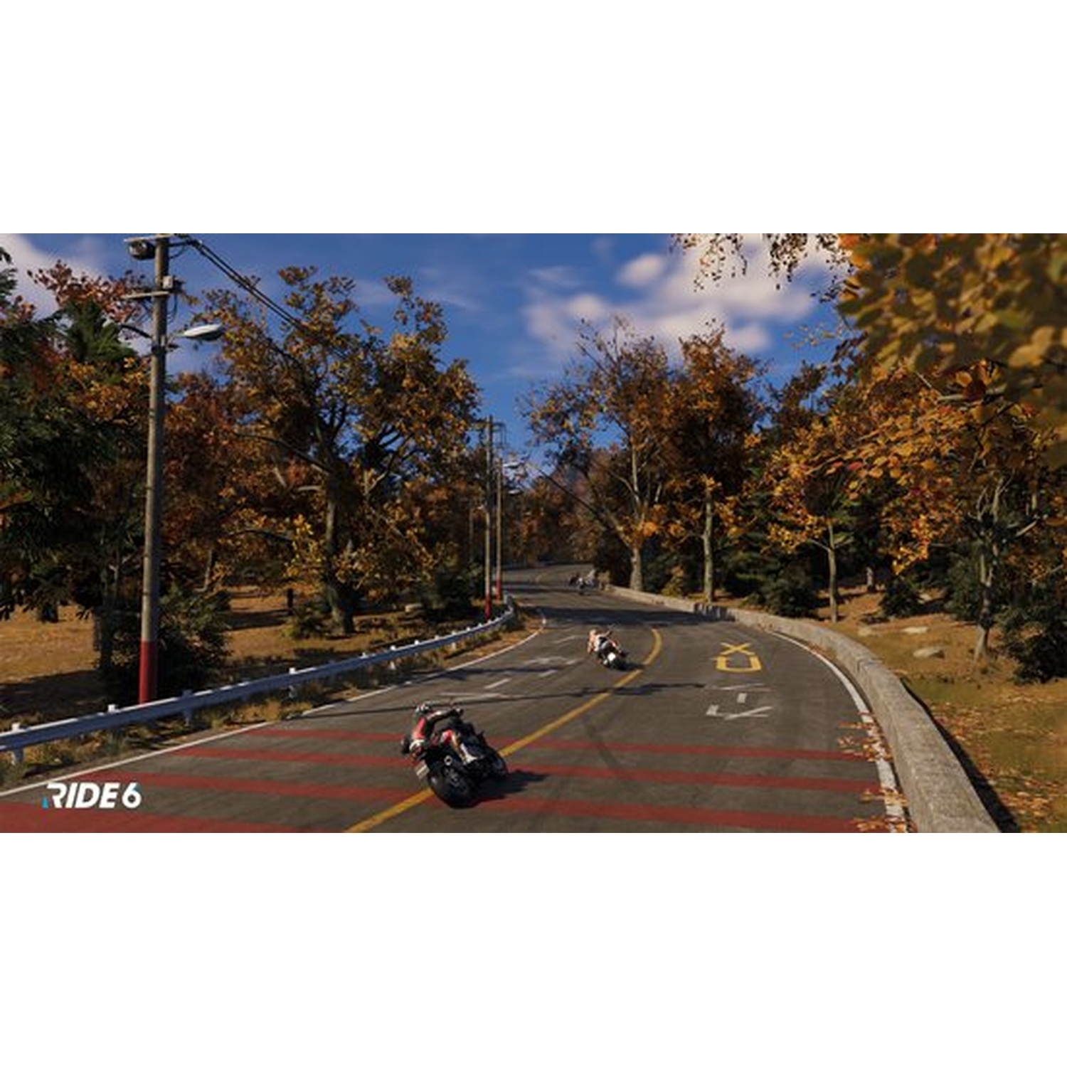 Motos de course sur une route sinueuse à travers une forêt en automne. Des couleurs rouge, jaune et vert sont visibles. Le ciel est bleu.