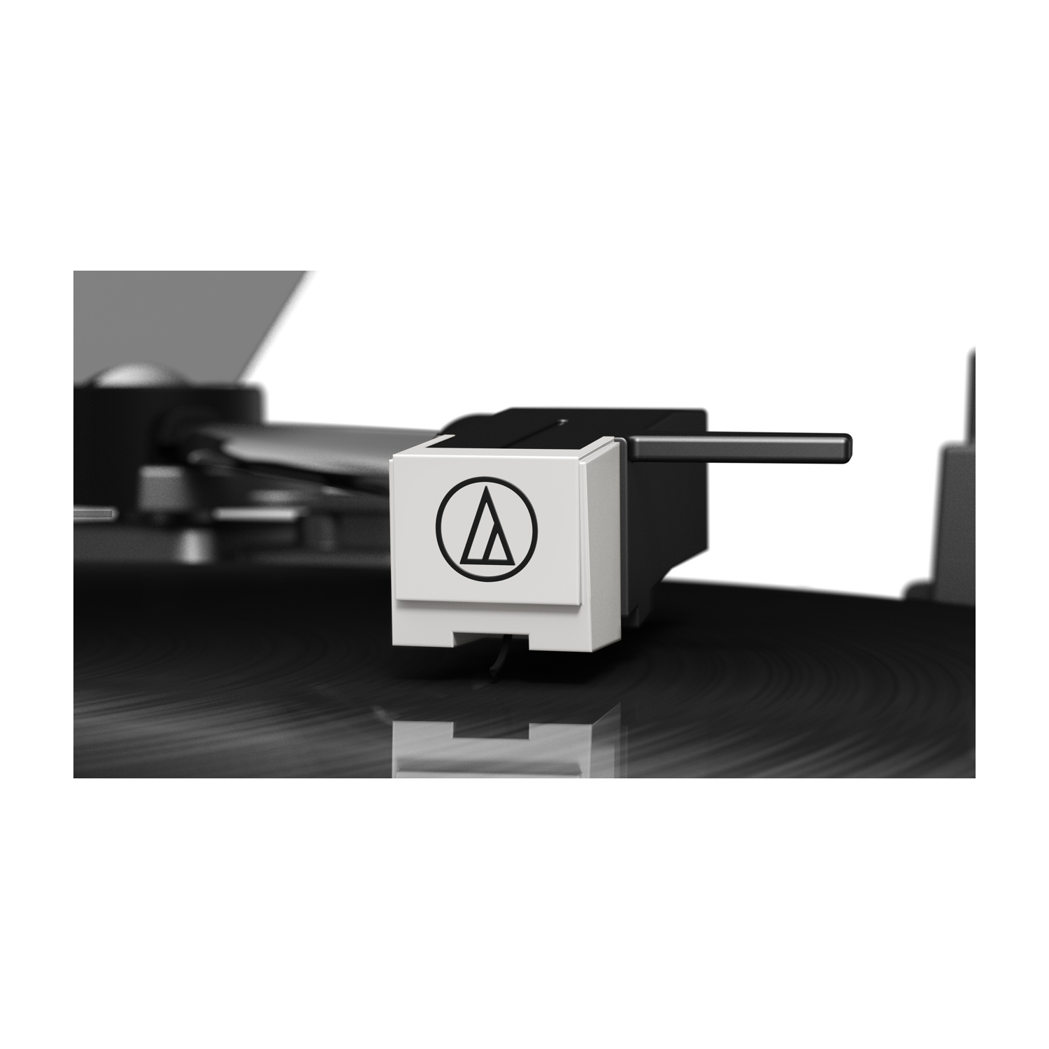 Primo piano dello stilo di un giradischi su un disco in vinile nero. Lo stilo ha un involucro bianco con un logo nero e un braccio nero.