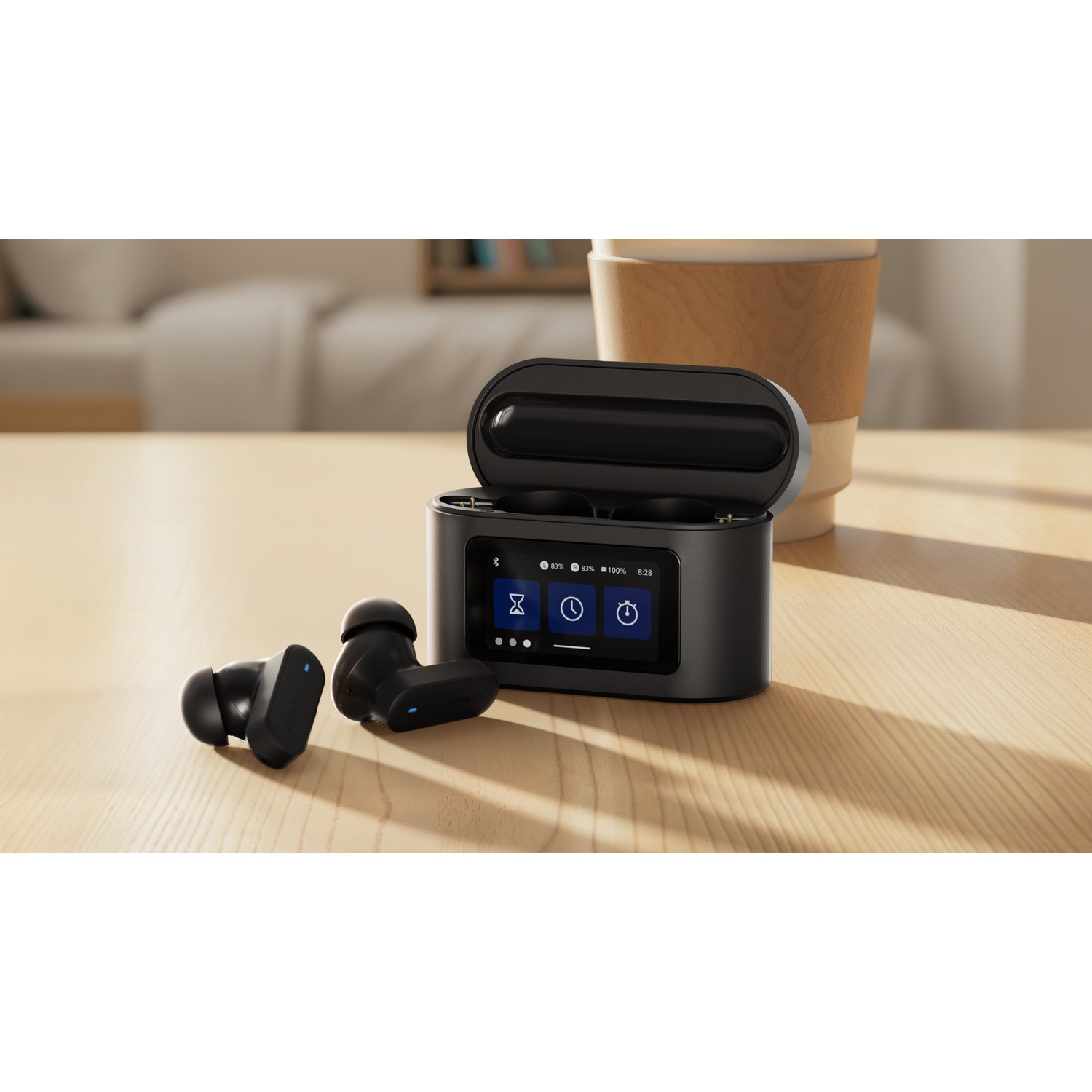 Auricolari wireless neri con custodia di ricarica su un tavolo di legno. Una tazza di caffè è sullo sfondo.
