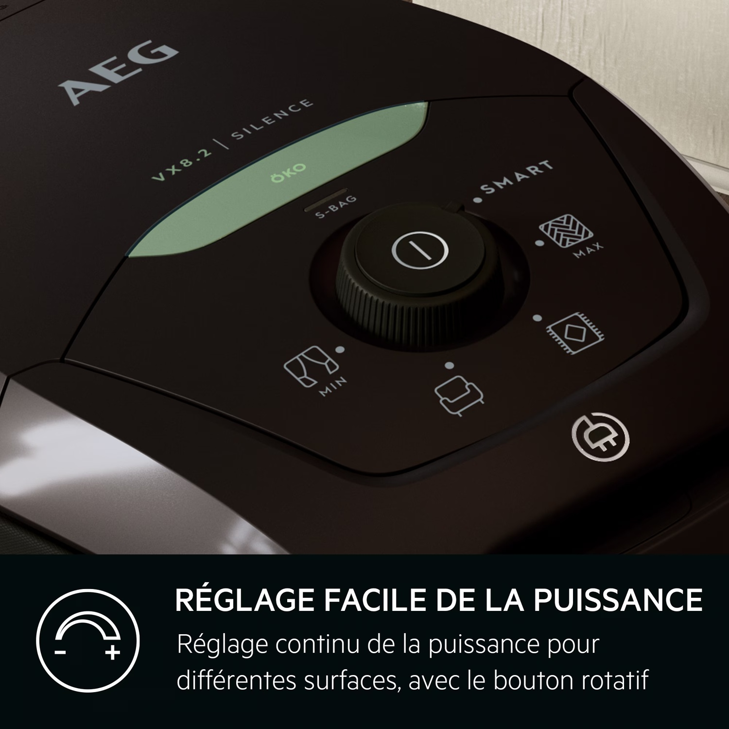 Gros plan sur le panneau de commande d'un aspirateur AEG noir. Il comporte une molette de réglage, des boutons et des étiquettes de texte comme 'SILENCE' et 'SMART'.