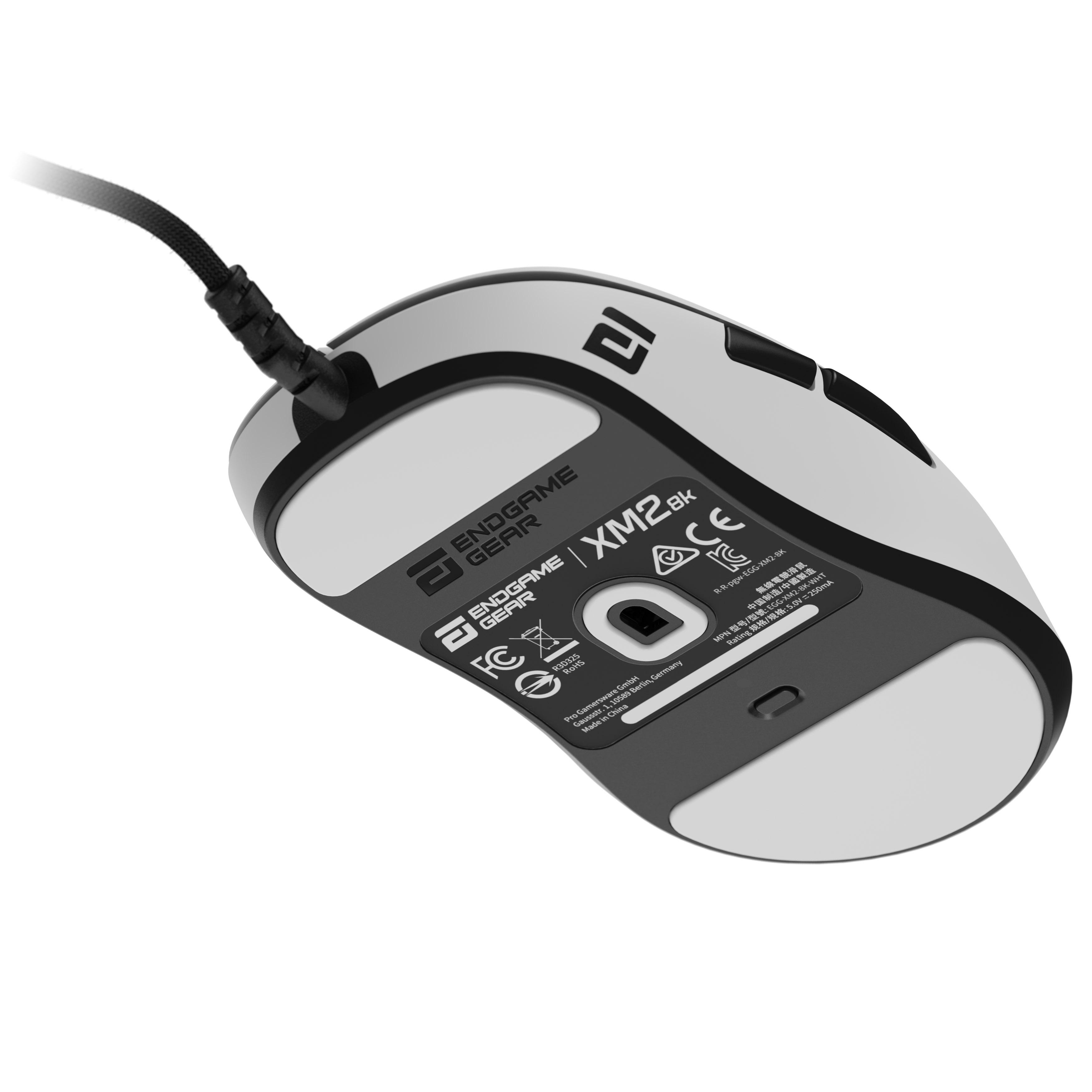 Eine weiße und schwarze Endgame Gear XM2w Gaming-Maus mit angeschlossenem Kabel, Unterseite sichtbar.