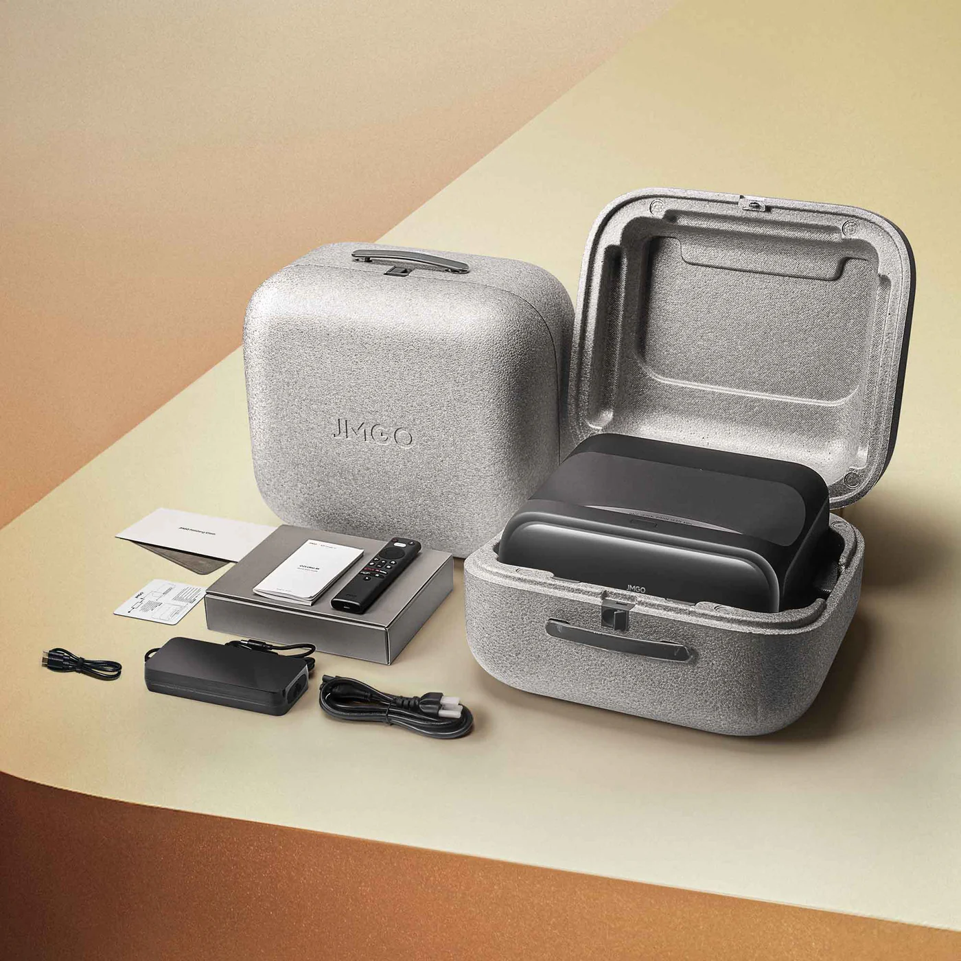 Kit projecteur JMGO. Comprend un projecteur, une télécommande, des câbles, un chargeur et des documents. Le tout dans une mallette.