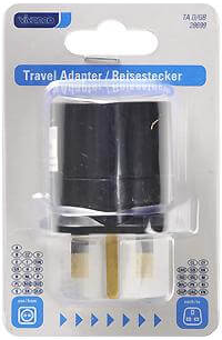 Reiseadapter in klarer Plastikverpackung. Schwarzer Adapter mit goldenen Stiften. Text: Travel Adapter / Reisestecker.