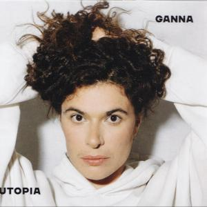 Eine Frau mit lockigem, dunklem Haar und einem weißen Kapuzenpullover. Das Wort GANNA steht über ihrem Kopf, UTOPIA darunter.