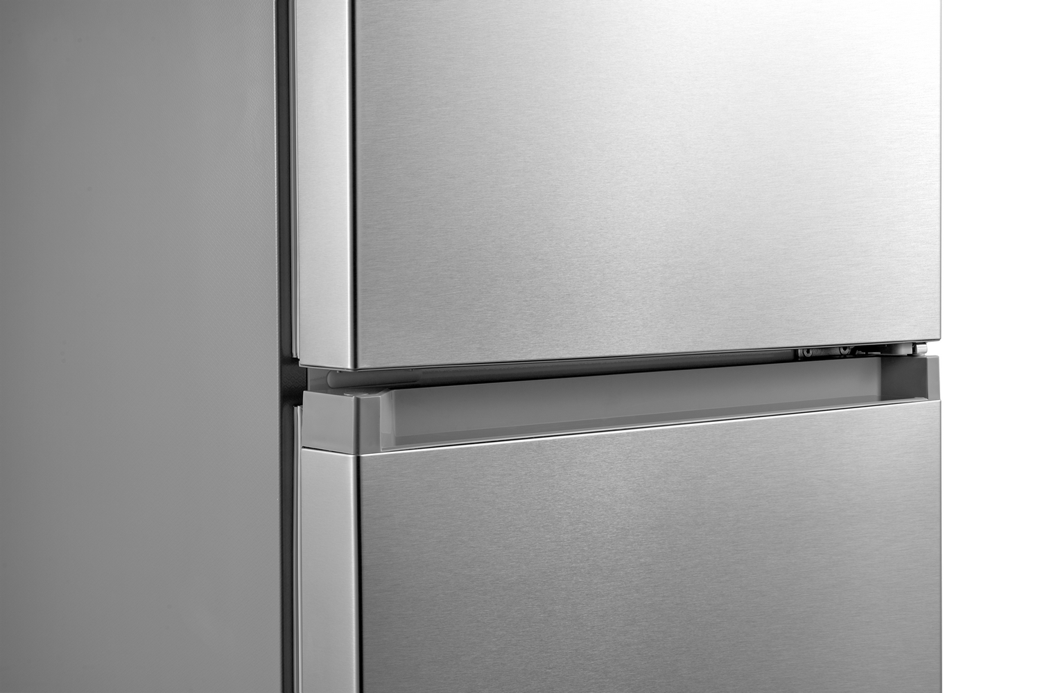 Primer plano de un refrigerador de acero inoxidable. La sección superior está cerrada. La sección inferior tiene un cajón parcialmente abierto.