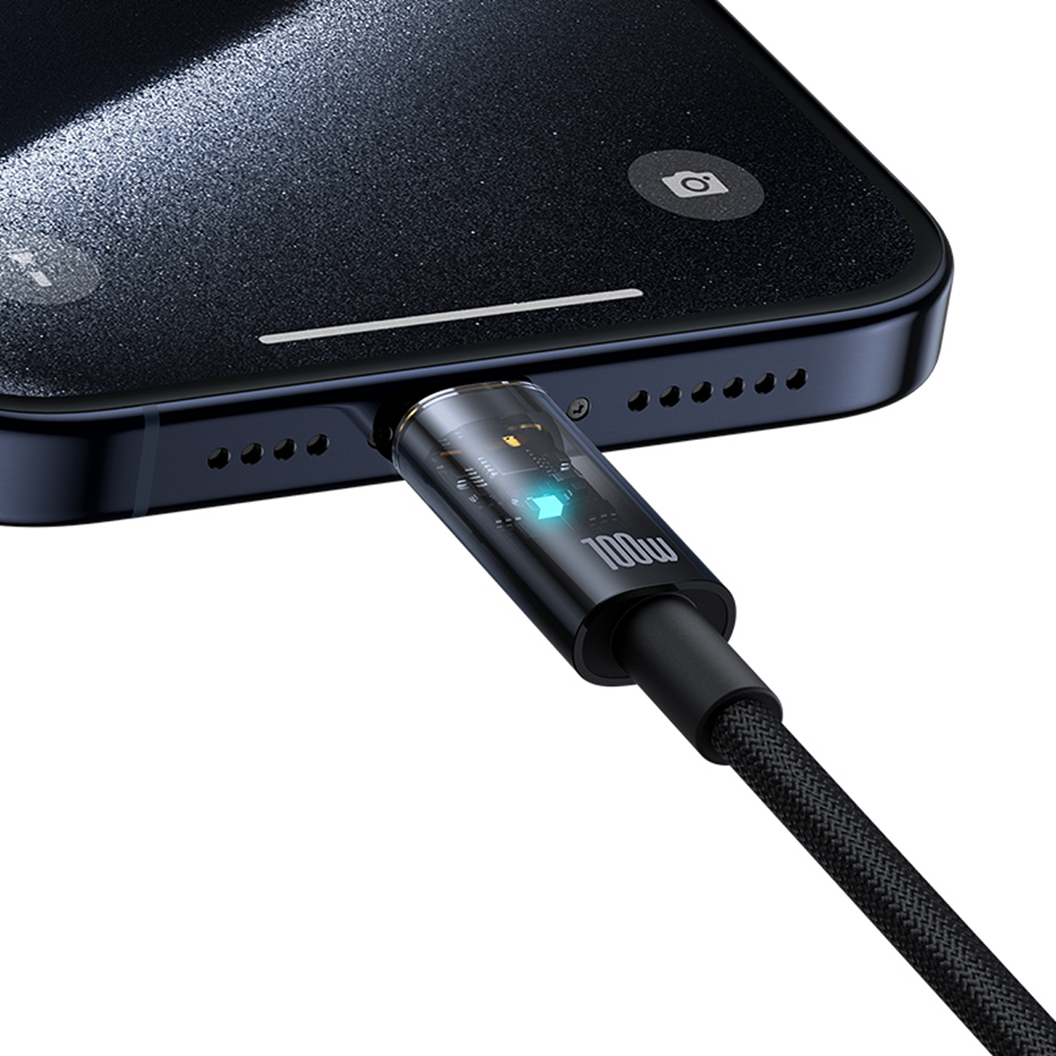 Un smartphone negro está conectado a un cable de carga. El cable tiene un conector transparente y brillante. El teléfono tiene un icono de cámara.