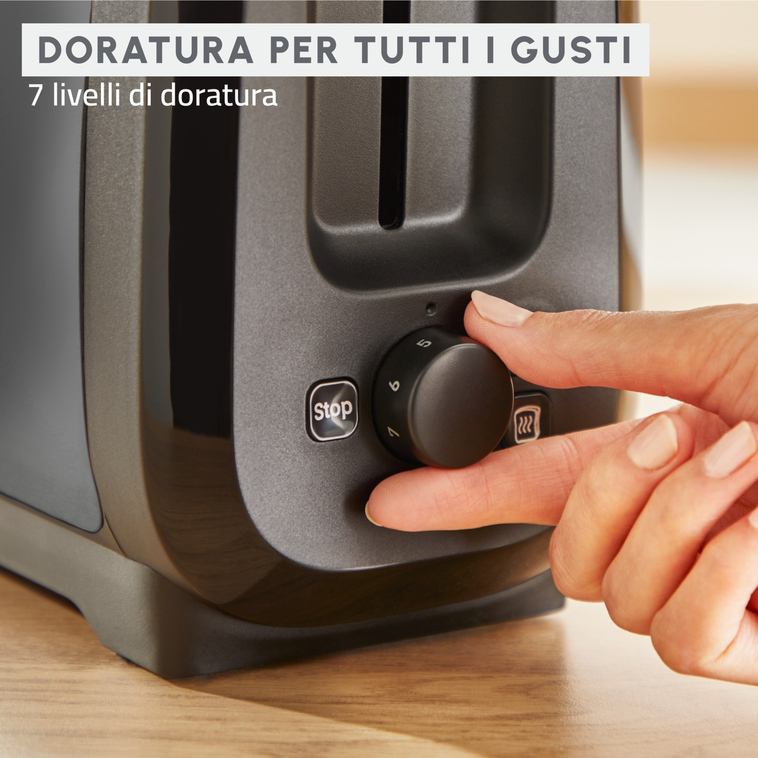 Una mano gira la manopola di un tostapane nero. Il quadrante mostra i numeri. Il testo indica 7 livelli di doratura.