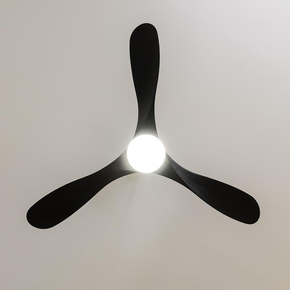Un ventilador de techo negro con tres aspas y luz central contra un techo blanco.