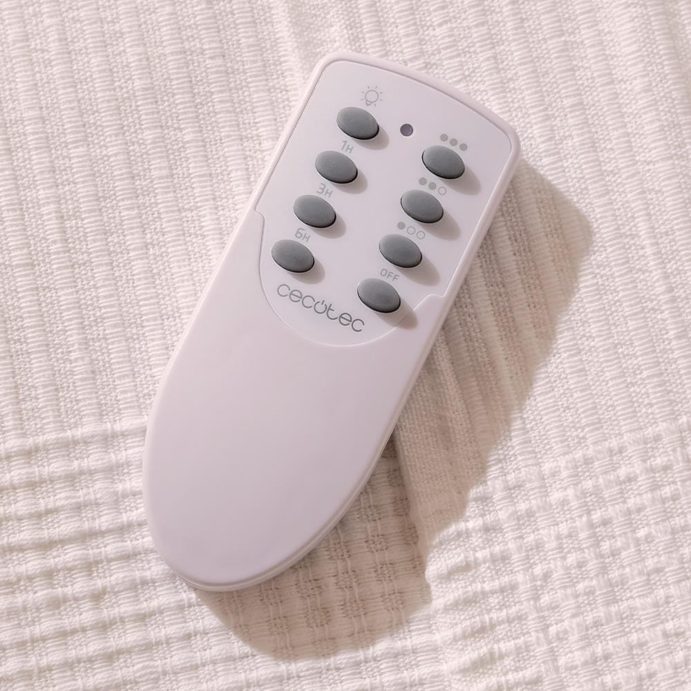 Un mando a distancia Cecotec blanco está sobre una tela blanca texturizada. El mando tiene botones para la luz y la temporización.