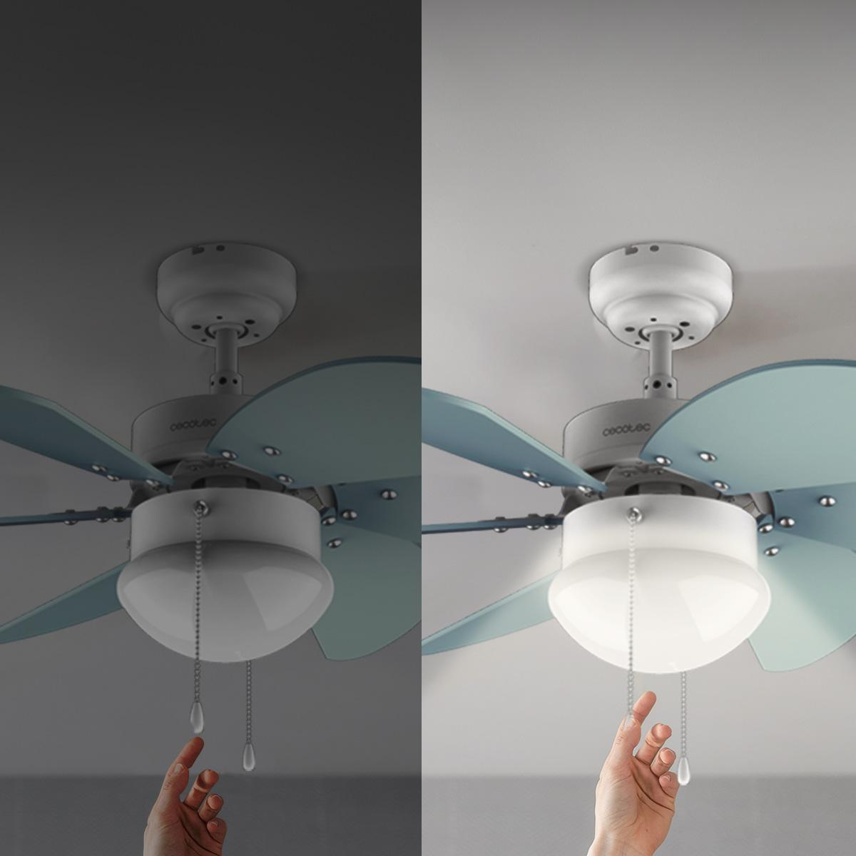 Una mano tira de la cadena de luz de un ventilador de techo. El ventilador tiene aspas azules y una luz blanca. El fondo es un techo blanco.