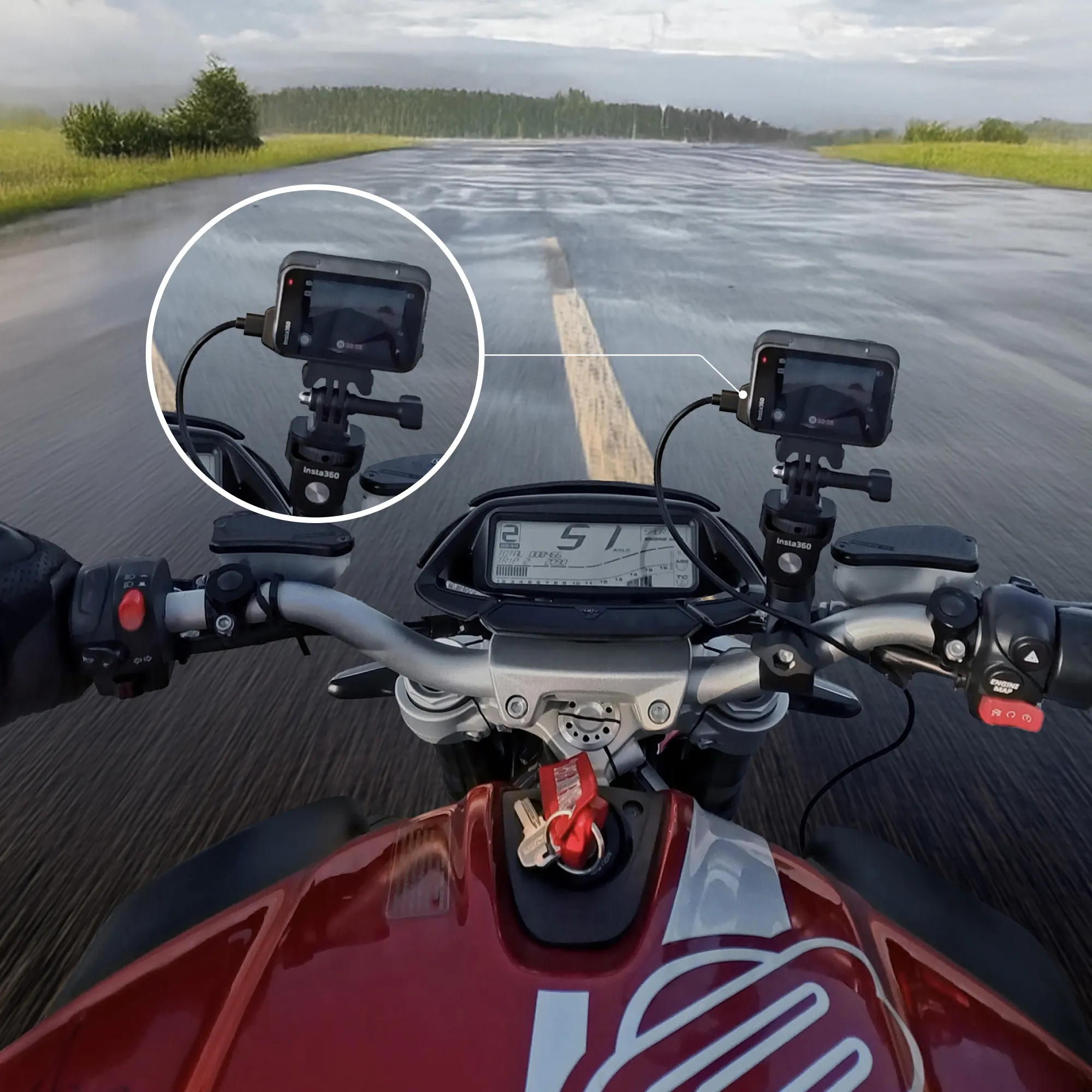 Motorrad-Armaturenbrett mit Kamera. Die Straße ist nass. Der Tacho zeigt 51. Das Motorrad ist rot und schwarz.