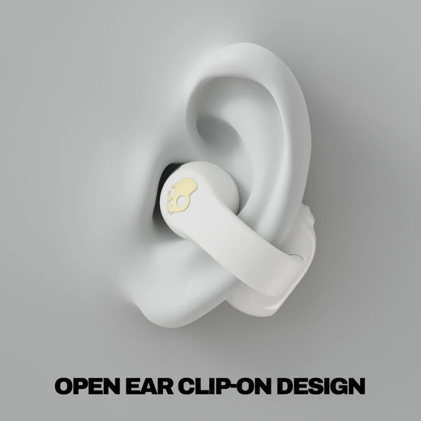 Weißer Ohrhörer mit goldenem Totenkopf-Logo an einem weißen Ohrmodell befestigt. Das Bild hat einen grauen Hintergrund mit Text unten.