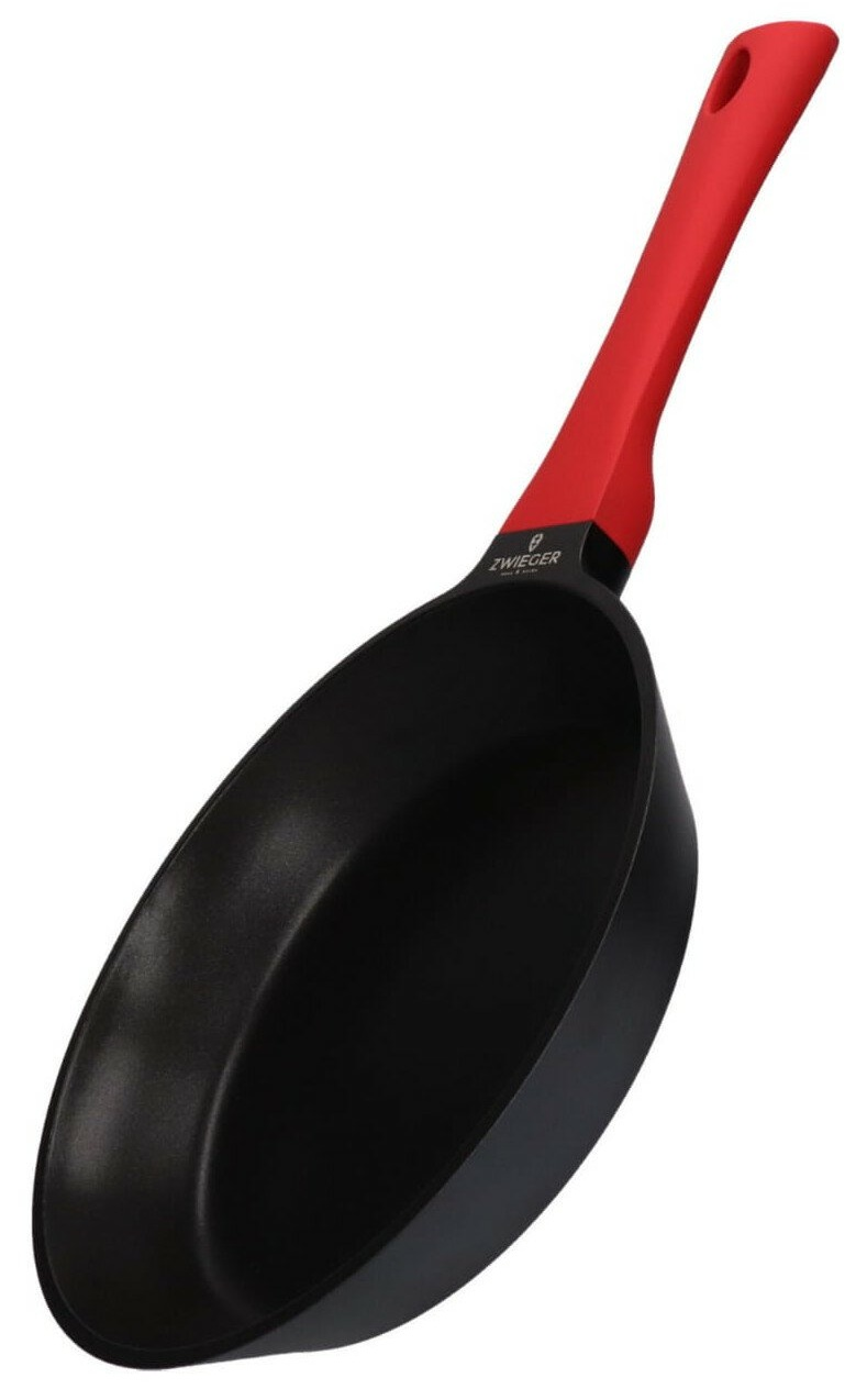 Czarna patelnia z czerwonym uchwytem. Uchwyt ma otwór. Na patelni widoczne jest logo.