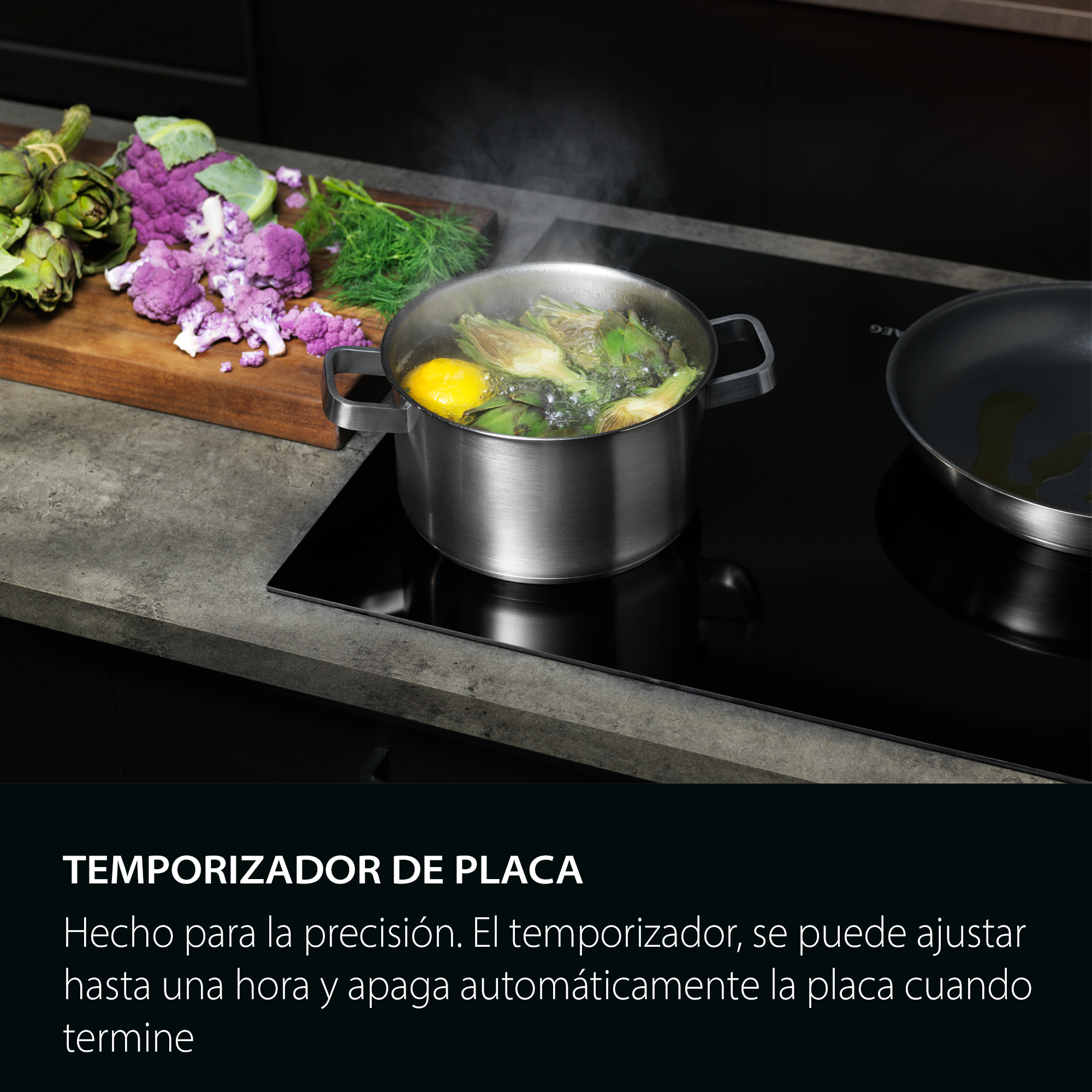 Una olla con alcachofas y un limón hierve en una placa negra, junto a una sartén. Coliflor morada y eneldo sobre una tabla.