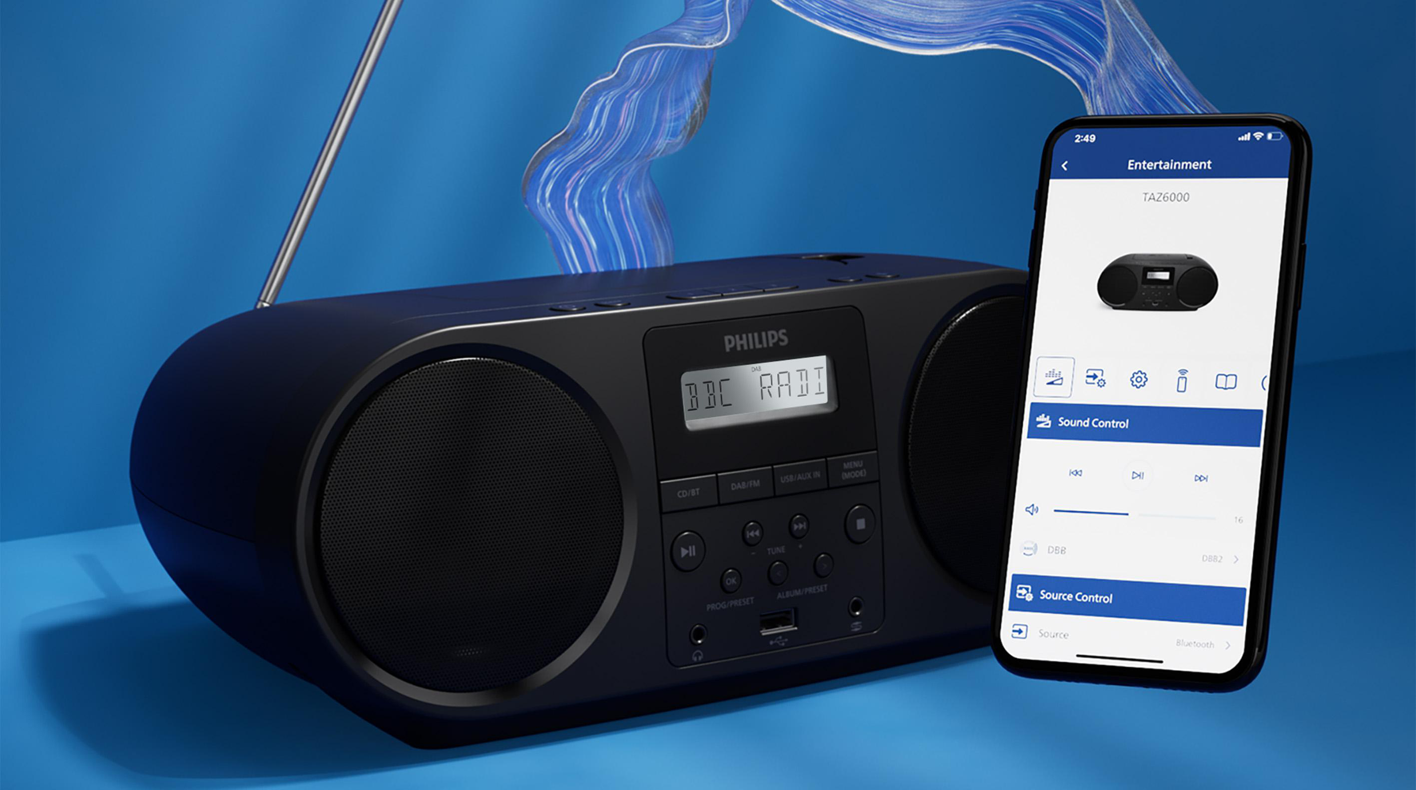 Ein schwarzes Philips-Radio und ein Smartphone mit seiner Oberfläche auf blauem Hintergrund. Das Radio zeigt 'BBC RADIO'.