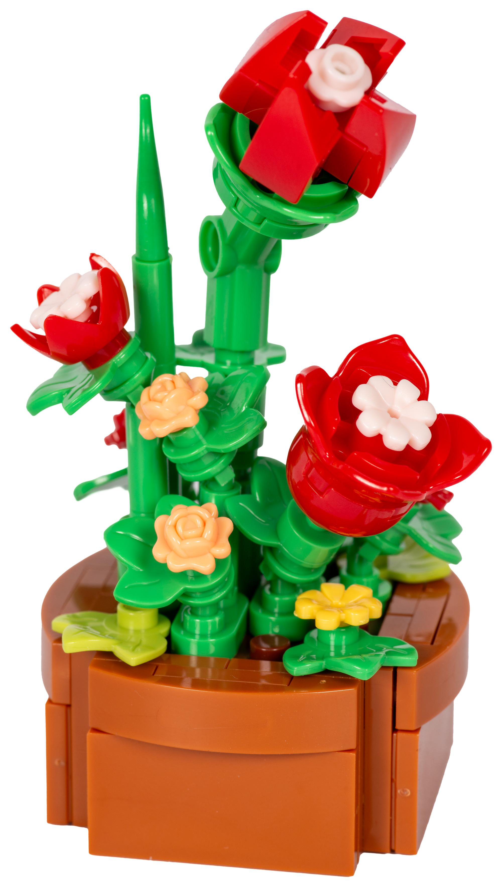 Eine Lego-Pflanze mit roten und weißen Blüten, grünen Stielen und Blättern sowie einem braunen Topf. Enthält gelbe und orangefarbene Blumen.