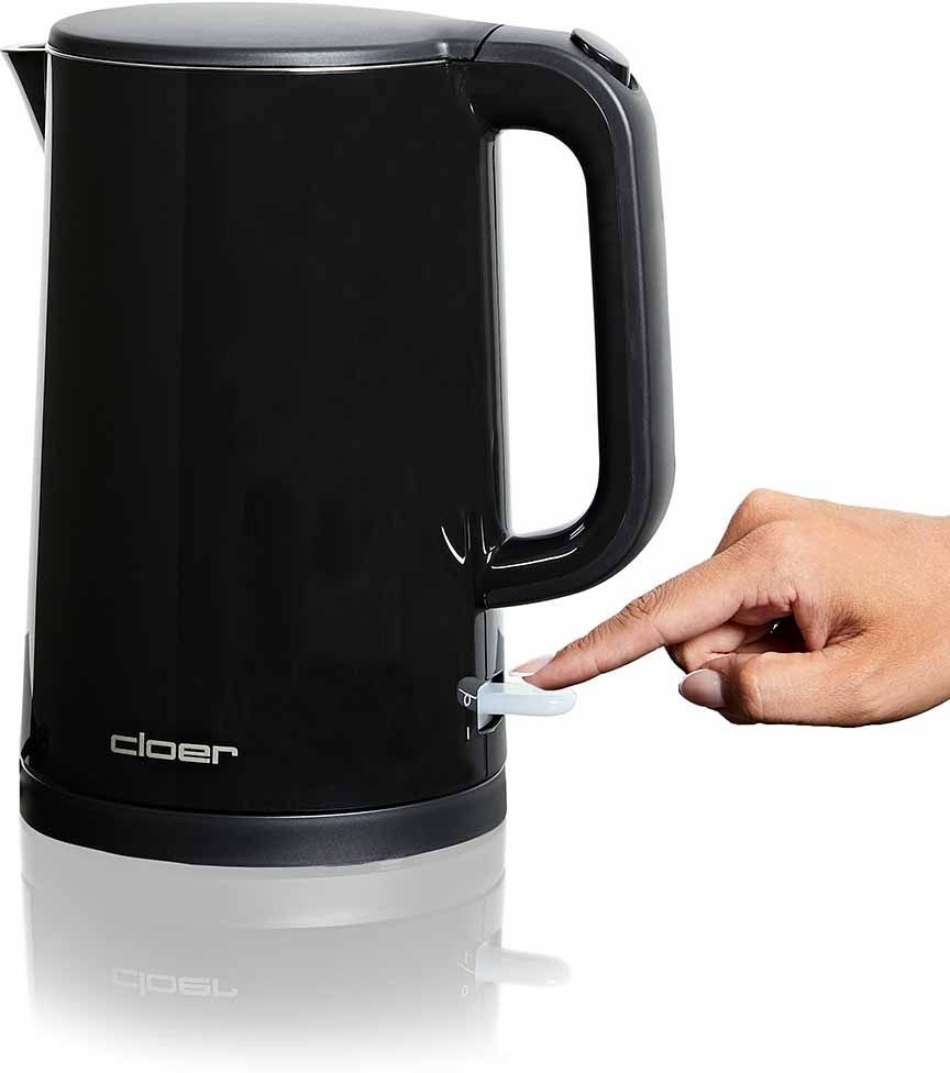Ein schwarzer Wasserkocher, eine Hand drückt den Einschalter. Der Wasserkocher steht auf einer weißen Oberfläche.