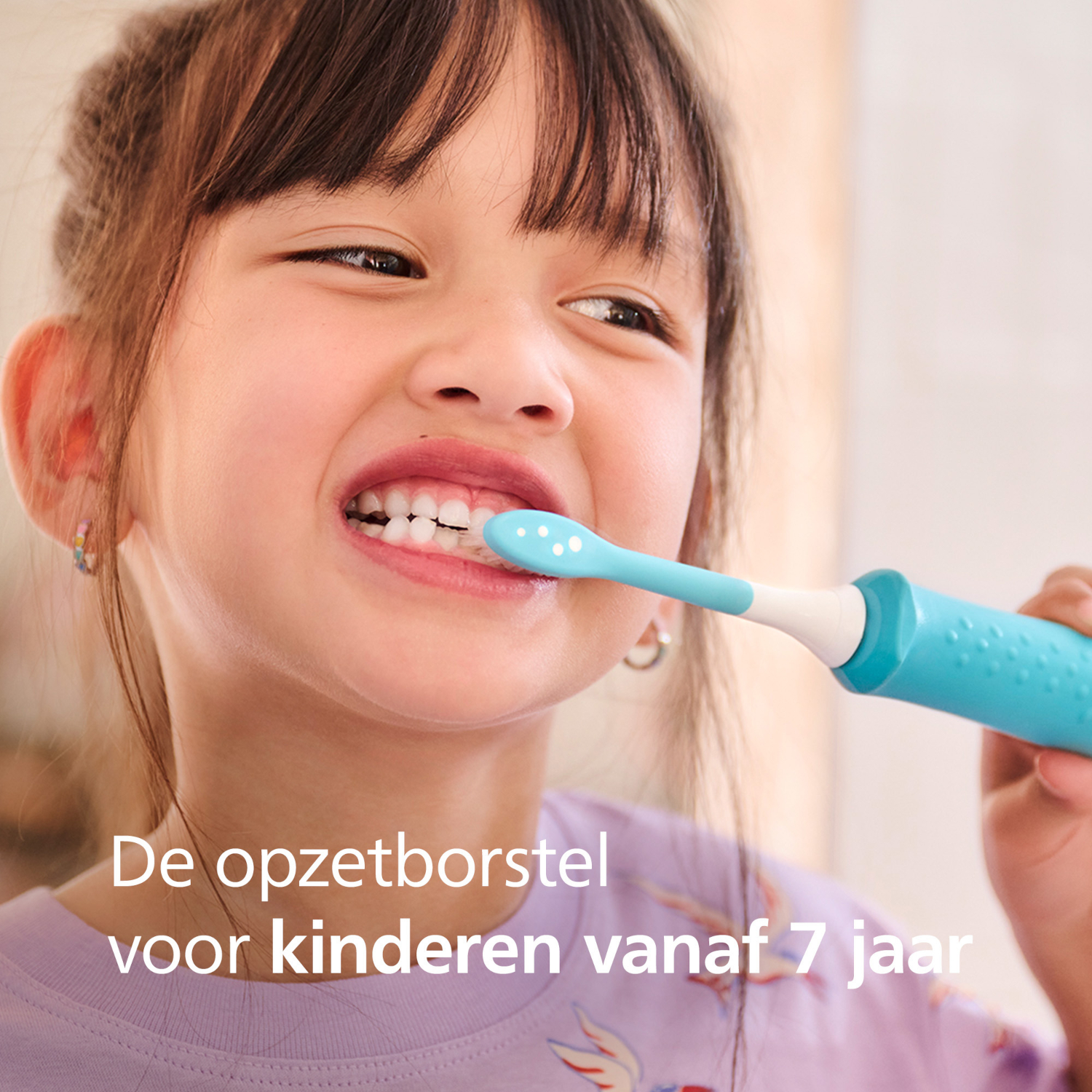 A young girl brushes her teeth with a blue toothbrush. She is smiling. Text at the bottom says 'toothbrush for children from 7 years'.