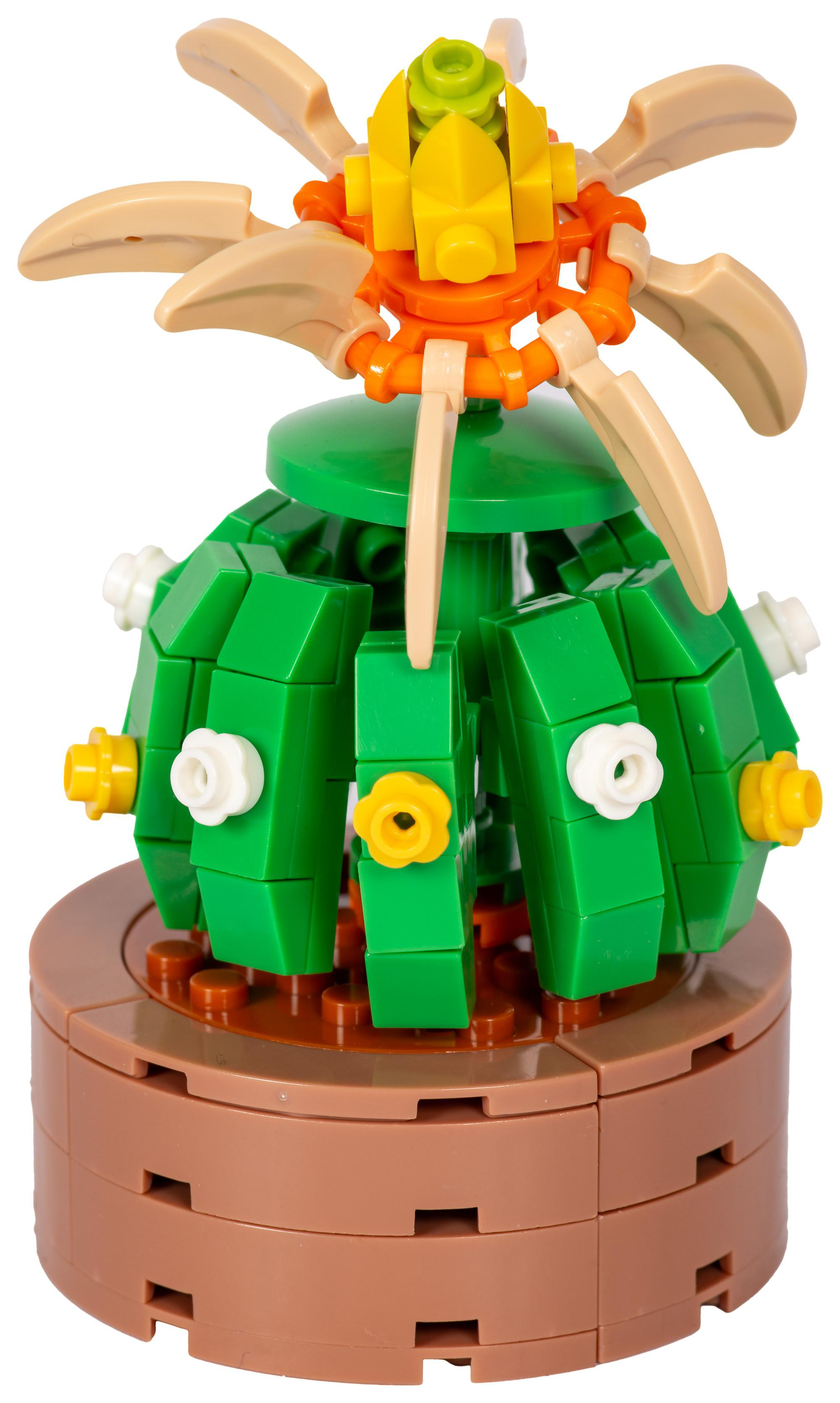 Ein Lego-Kaktusmodell mit grünem Körper, orangefarbener und gelber Blume. Es sitzt auf einem braunen Topf. Beige Blätter erstrecken sich nach außen.