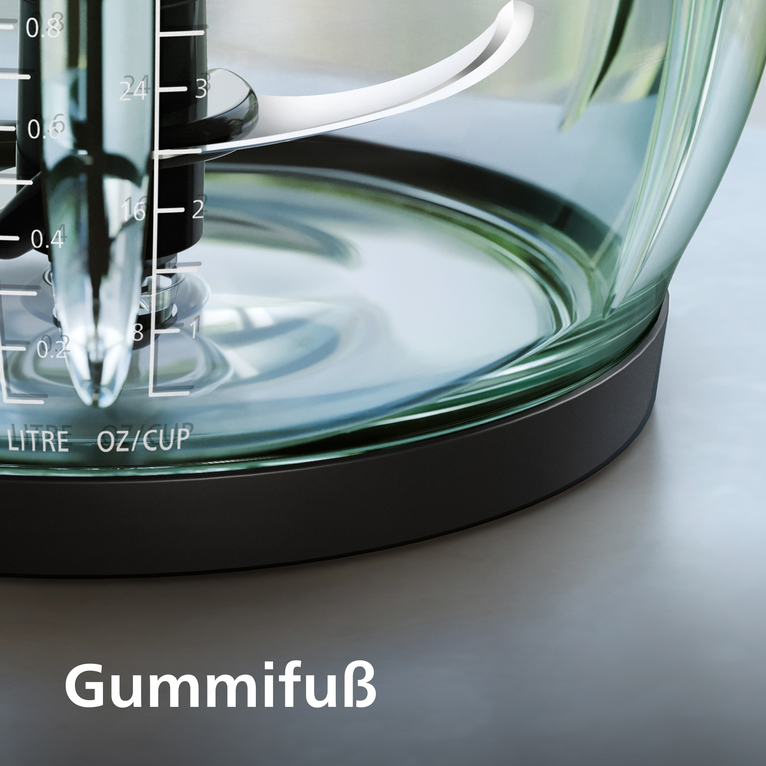 Nahaufnahme eines Mixers mit einem transparenten Glasbehälter. Messmarkierungen sind sichtbar. Das Wort "Gummifuß" steht unten.