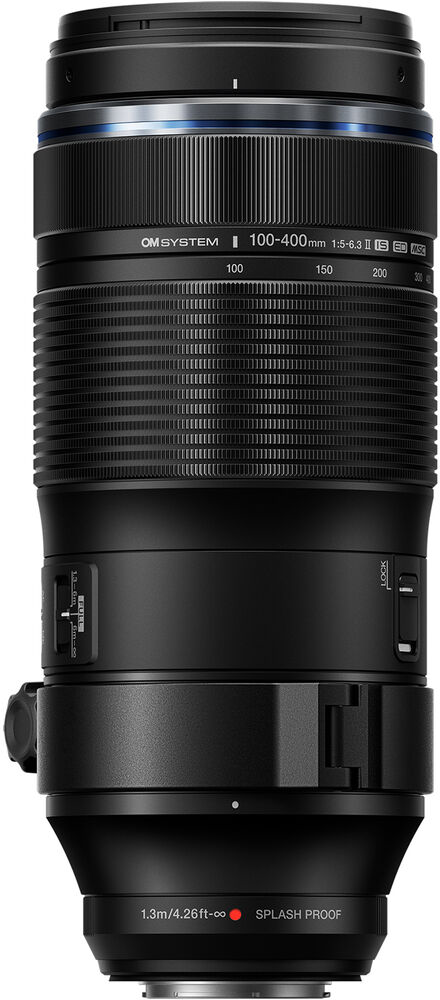 Fekete kameraobjektív OM SYSTEM jelölésekkel. 100-400 mm-es zoom tartománnyal rendelkezik, cseppálló.