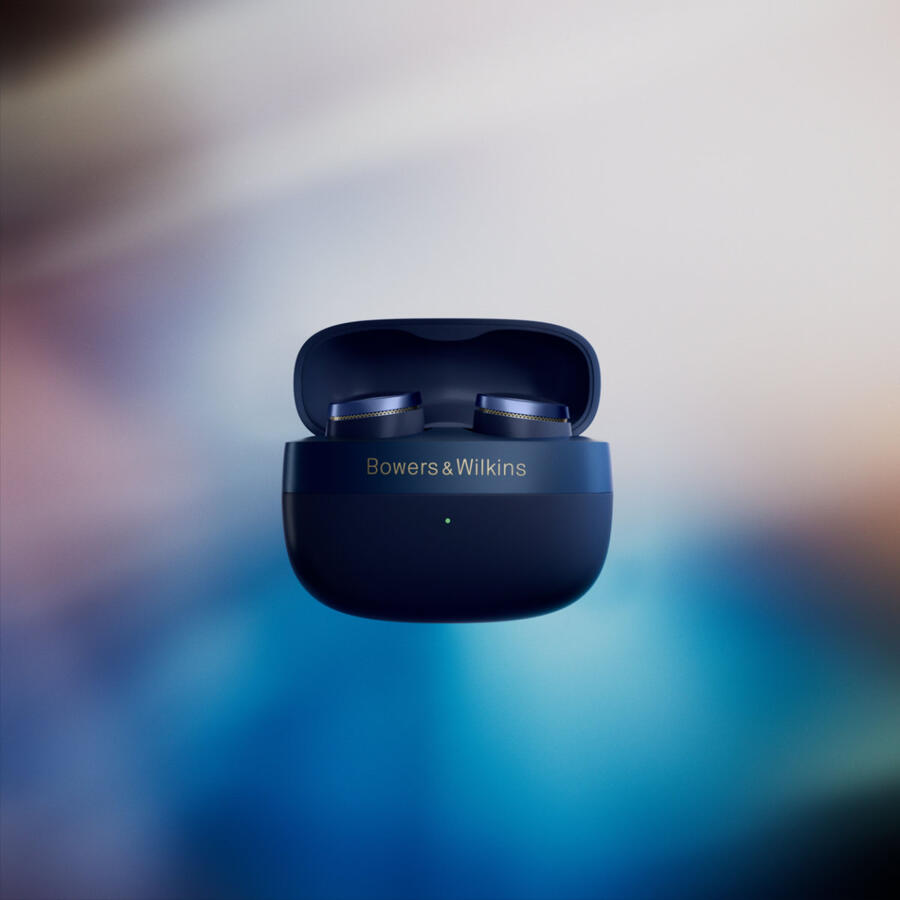 Nyitott sötétkék fülhallgató tok két fülhallgatóval. A tokon a 'Bowers & Wilkins' márkanév látható. A háttér kék és fehér átmenet.