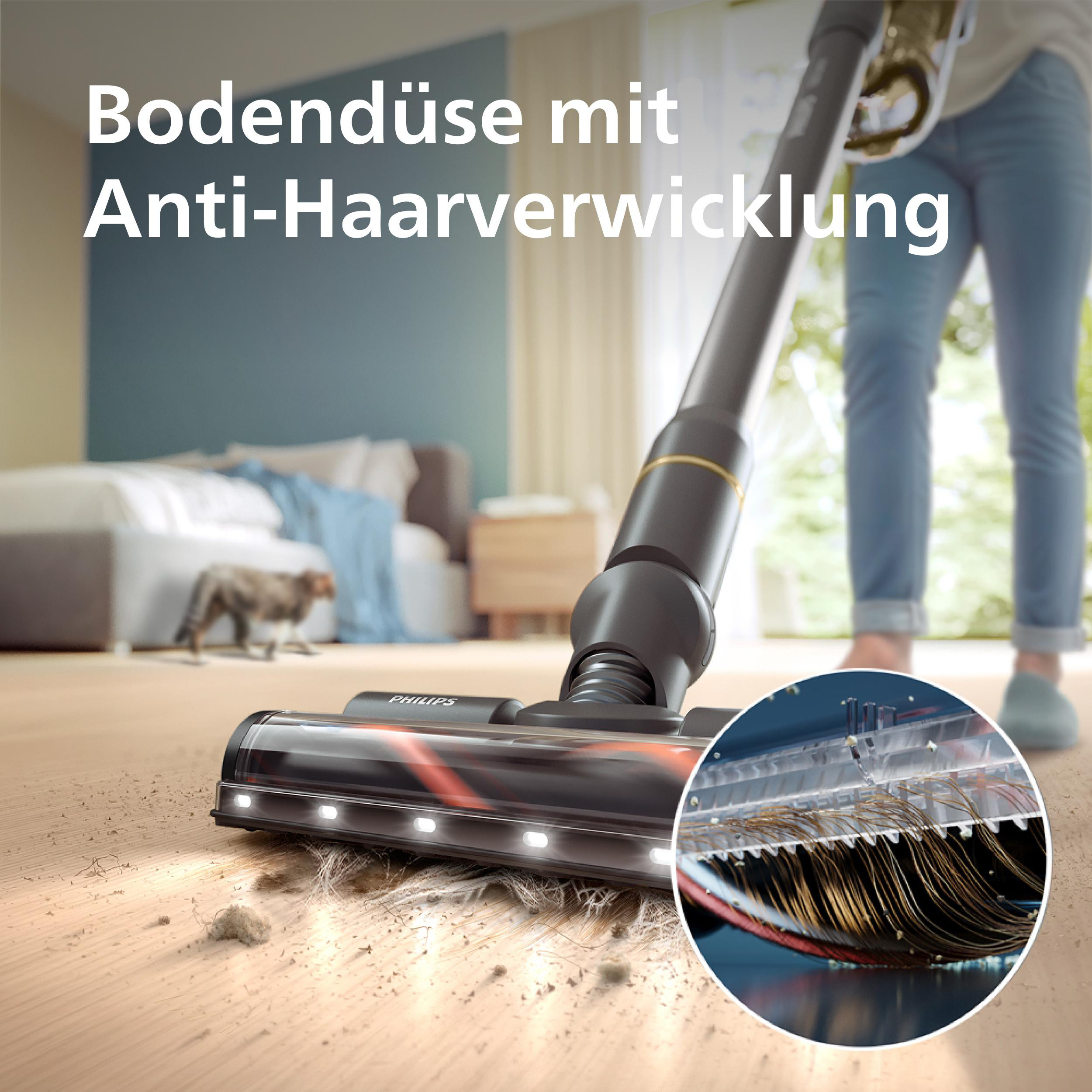 Eine Person saugt einen Raum. Der Staubsaugerkopf befindet sich auf einem Holzboden mit Staub und Haaren. Eine Katze geht im Hintergrund.