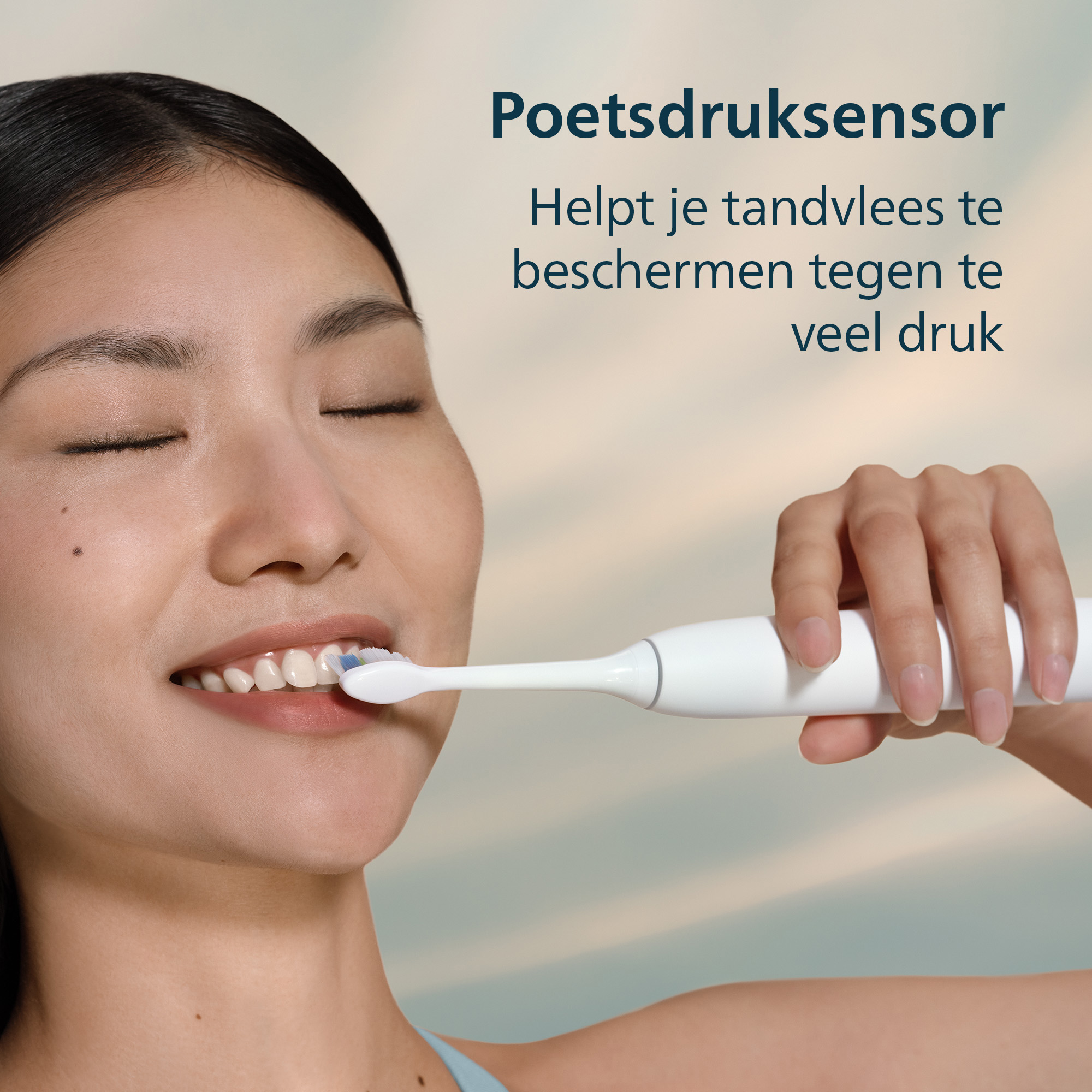 A woman brushes her teeth with a white electric toothbrush. Text: Pressure sensor helps protect gums from pressure.