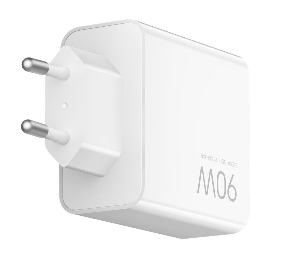 Egy fehér Xiaomi M06 90W töltő. Két ezüstszínű csatlakozóval és lekerekített élekkel rendelkező téglalap alakú testtel rendelkezik. A háttér fekete.