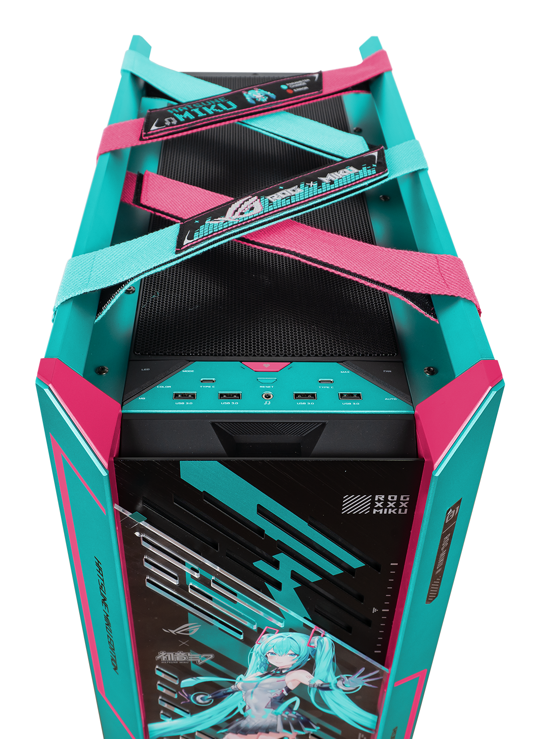 Ein teal- und pinkfarbenes Computergehäuse mit Hatsune Miku-Branding. Riemen kreuzen sich oben, mit Logos. Frontplatte hat USB-Anschlüsse.