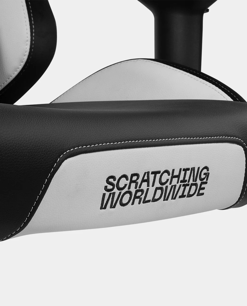 Primer plano de una silla gamer. La silla tiene cuero blanco y negro con las palabras 'SCRATCHING WORLDWIDE' en el lateral.