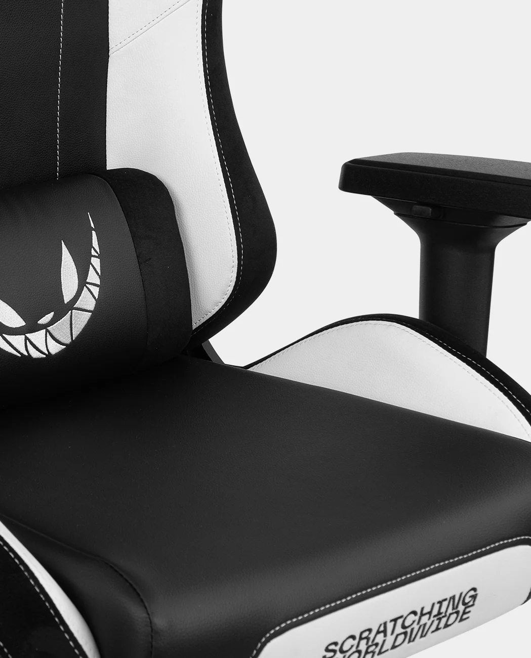 Silla gaming con diseño blanco y negro. Cuenta con reposacabezas con logo de cara sonriente. Reposabrazos negro.