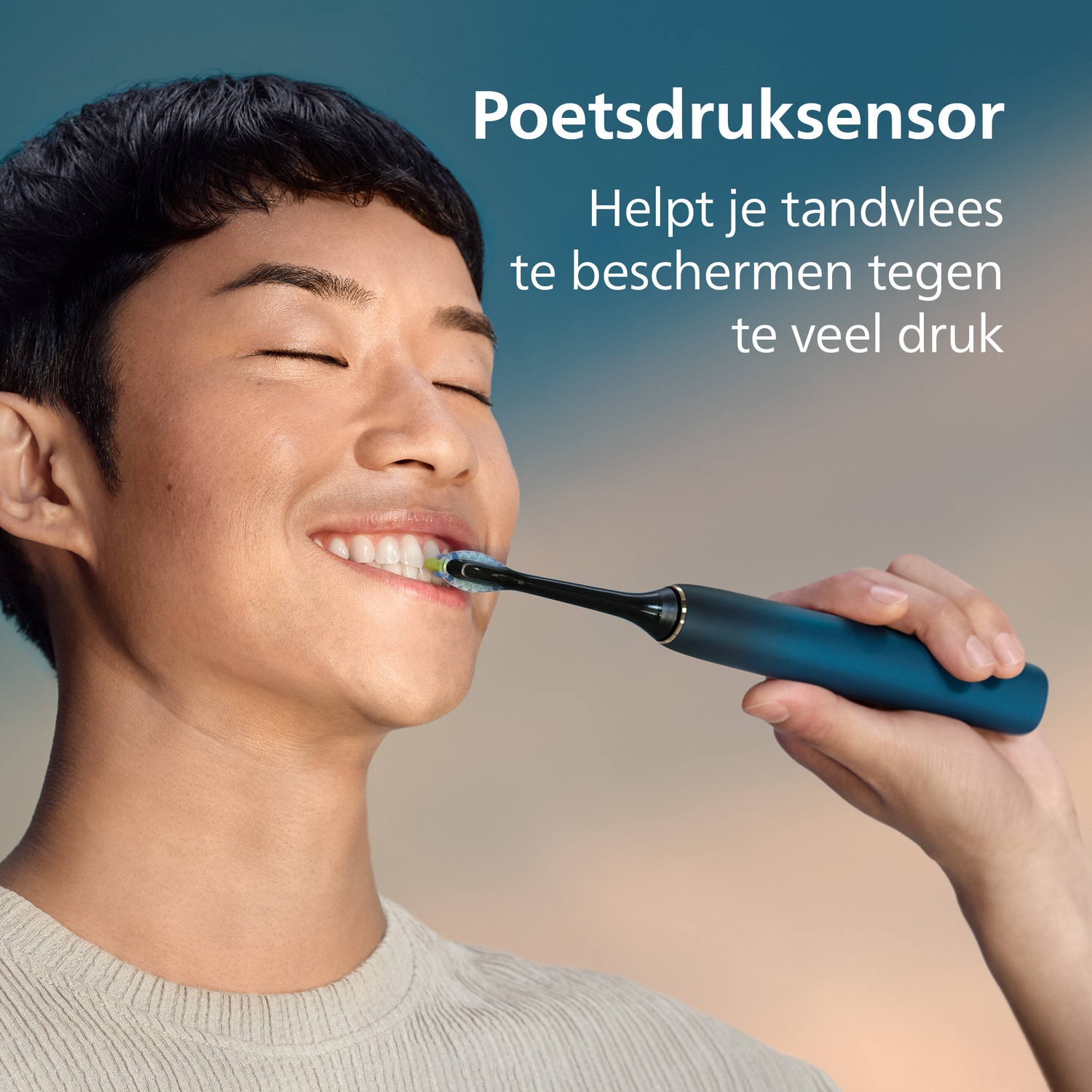 A man brushes his teeth with an electric toothbrush. He smiles with closed eyes. The background is a gradient of blue and orange.