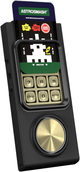 Una consola de juegos portátil Astrosmash. Tiene una pantalla, un teclado y un dial dorado. Un cartucho de juego se inserta en la parte superior.